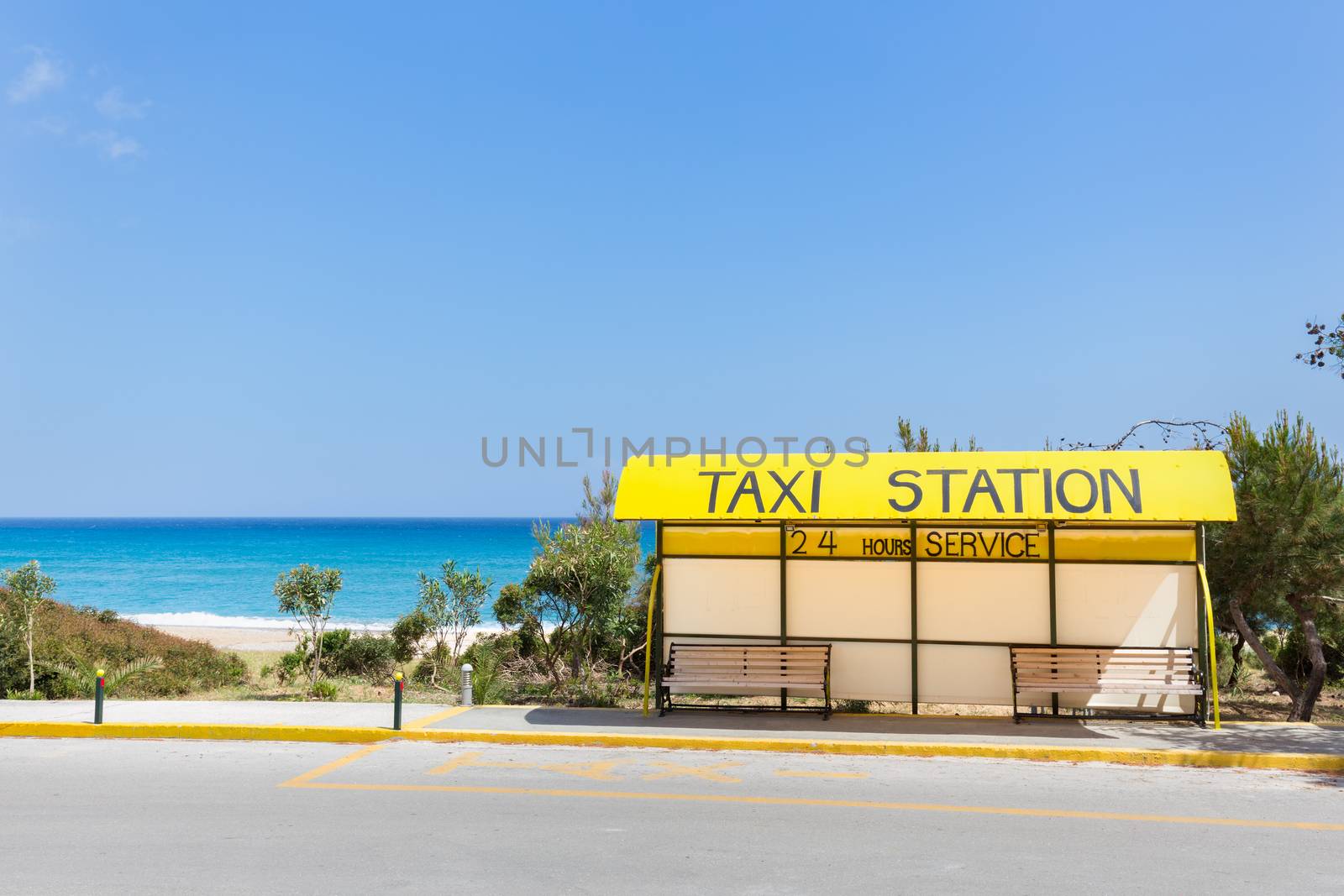 Taxi station near beach and sea in Greece by BenSchonewille