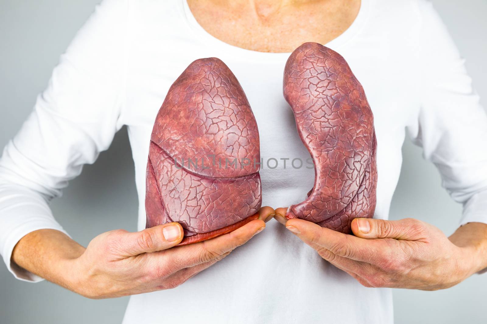 Woman showing two lungs in front of chest by BenSchonewille