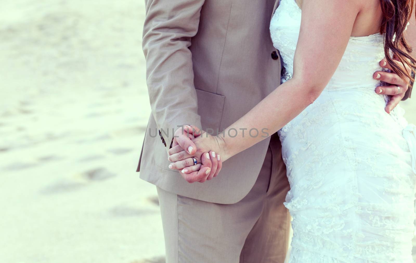 Bride and groom's hands with wedding rings on tropical beach. by kerdkanno