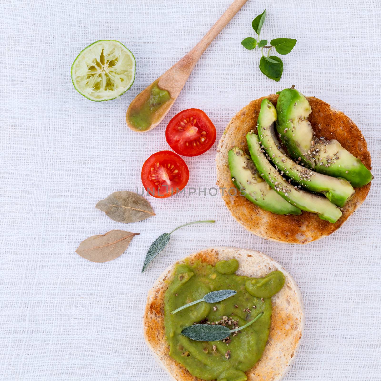 Toast with avocado creamy salad and herbs  on white table. by kerdkanno