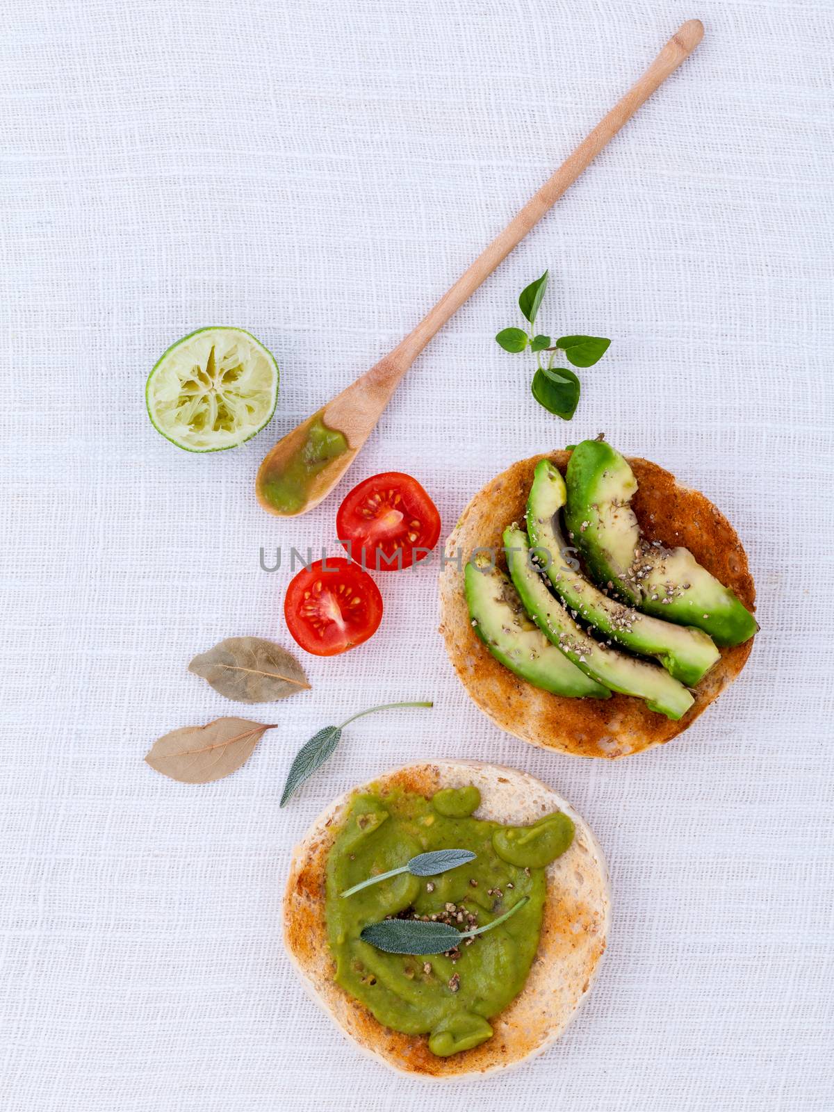 Toast with avocado creamy salad and herbs  on white table. by kerdkanno