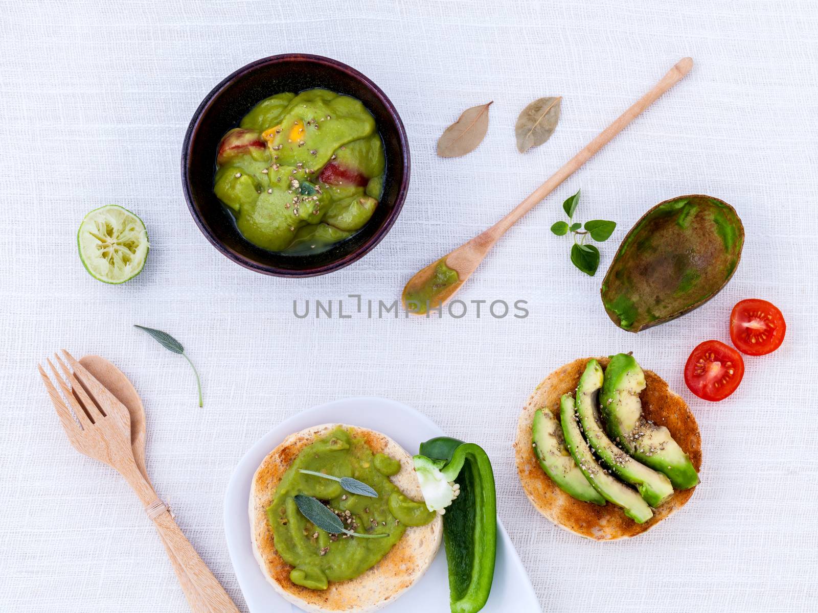 Toast with avocado creamy salad and herbs  on white table.