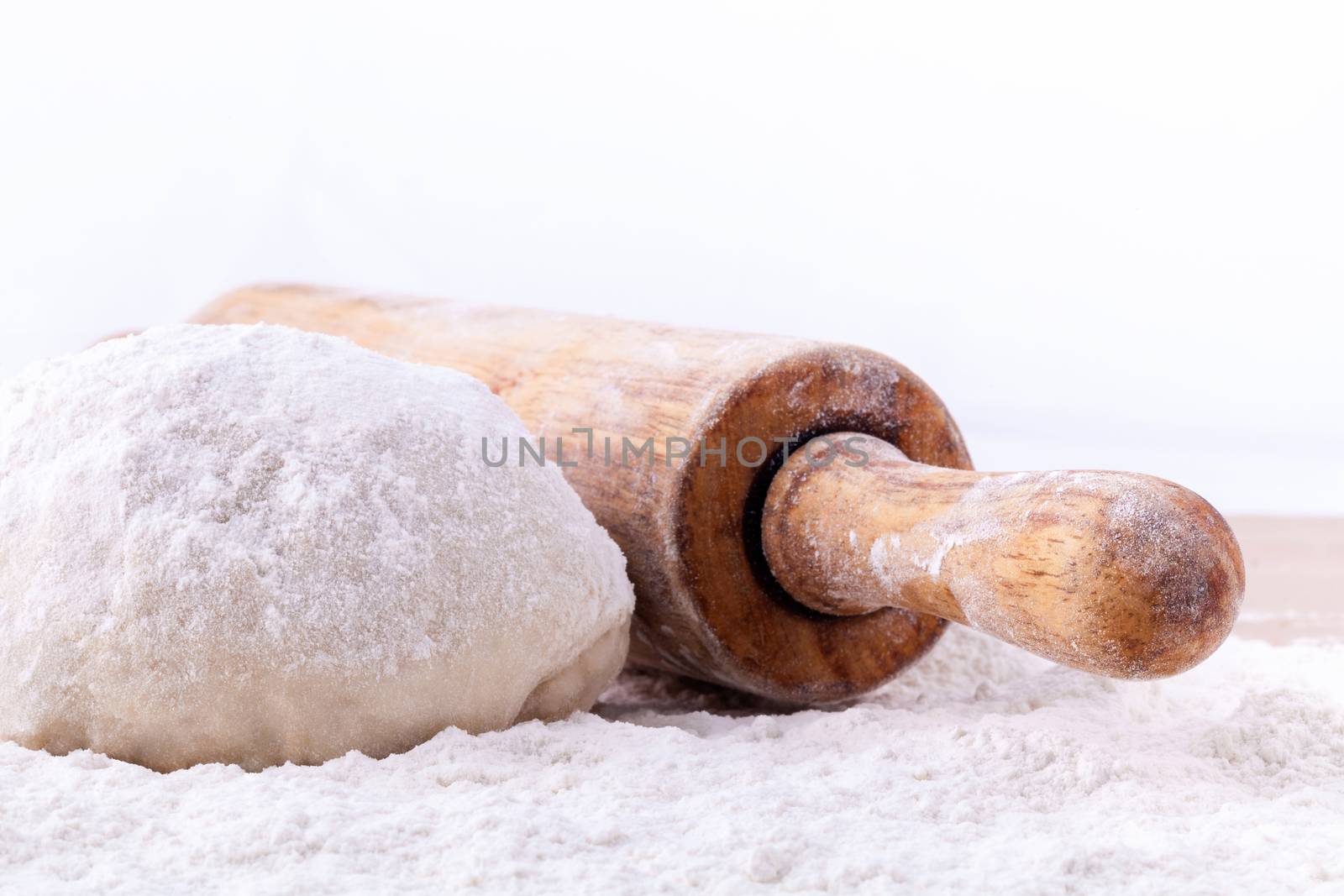 Baking ingredients  flour and a rolling pin on wooden table.