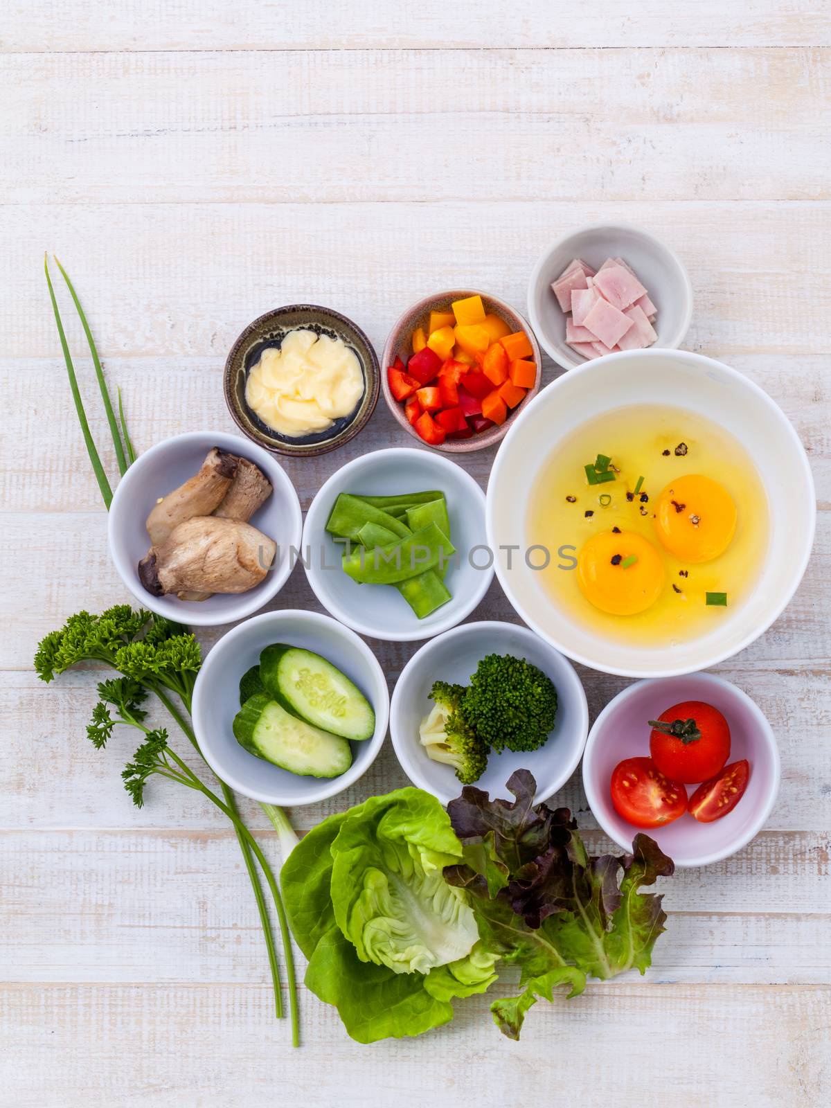 Ingredients of homemade omelet on wooden panel.