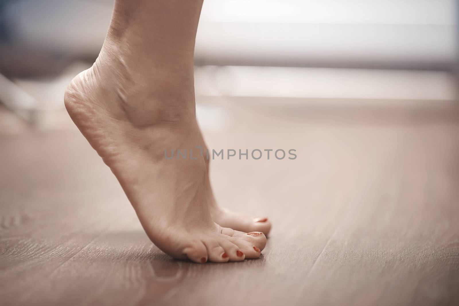 Feet of woman standing on tiptoe at home