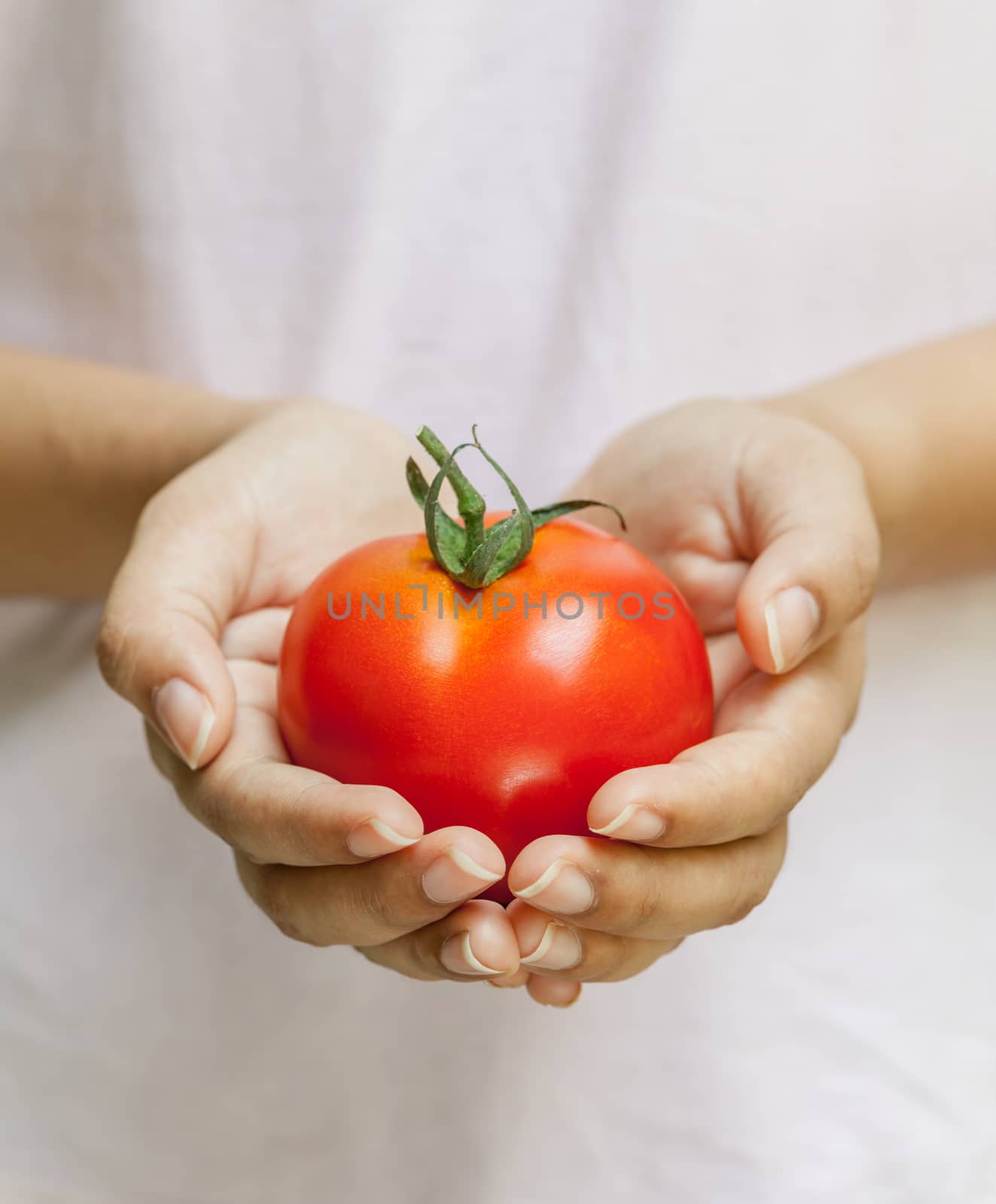 The Girl holding tomato. - Healthy food concept.