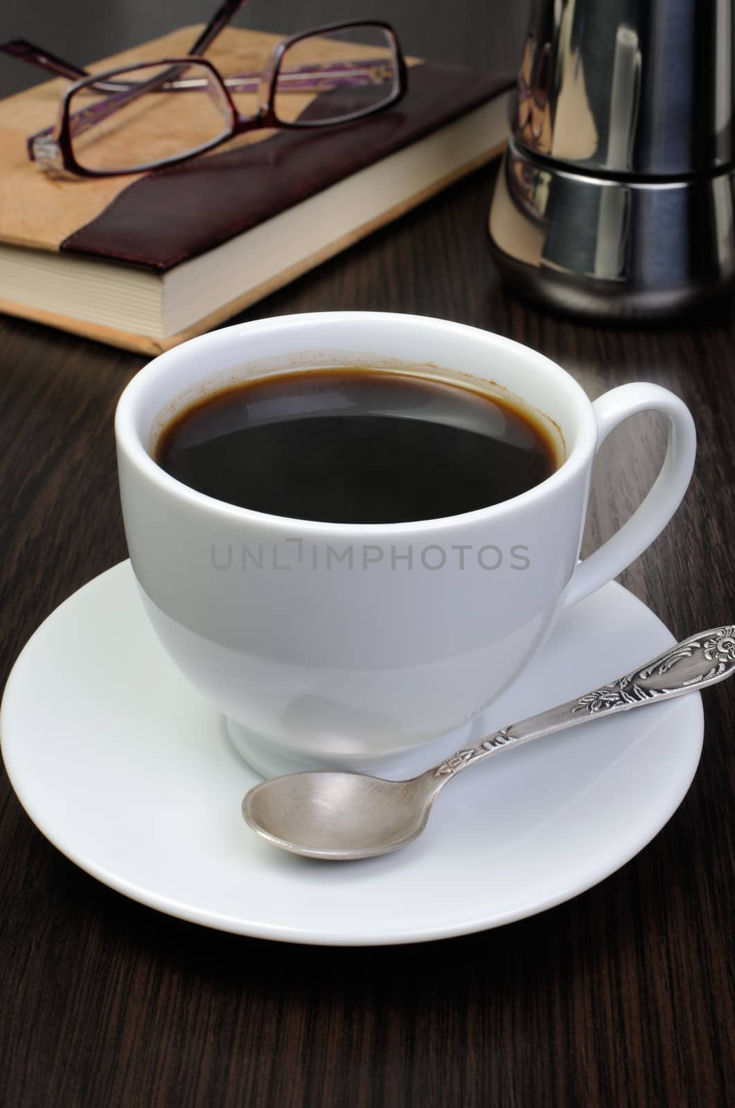 Coffee cup with   notepad and glasses on a table