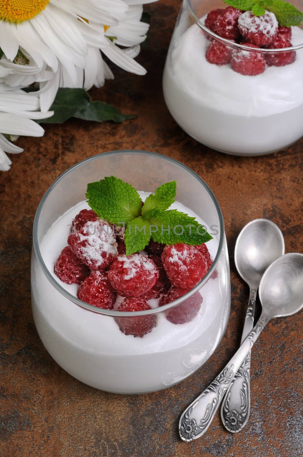 Dessert of whipped cream with raspberries and mint in a glass