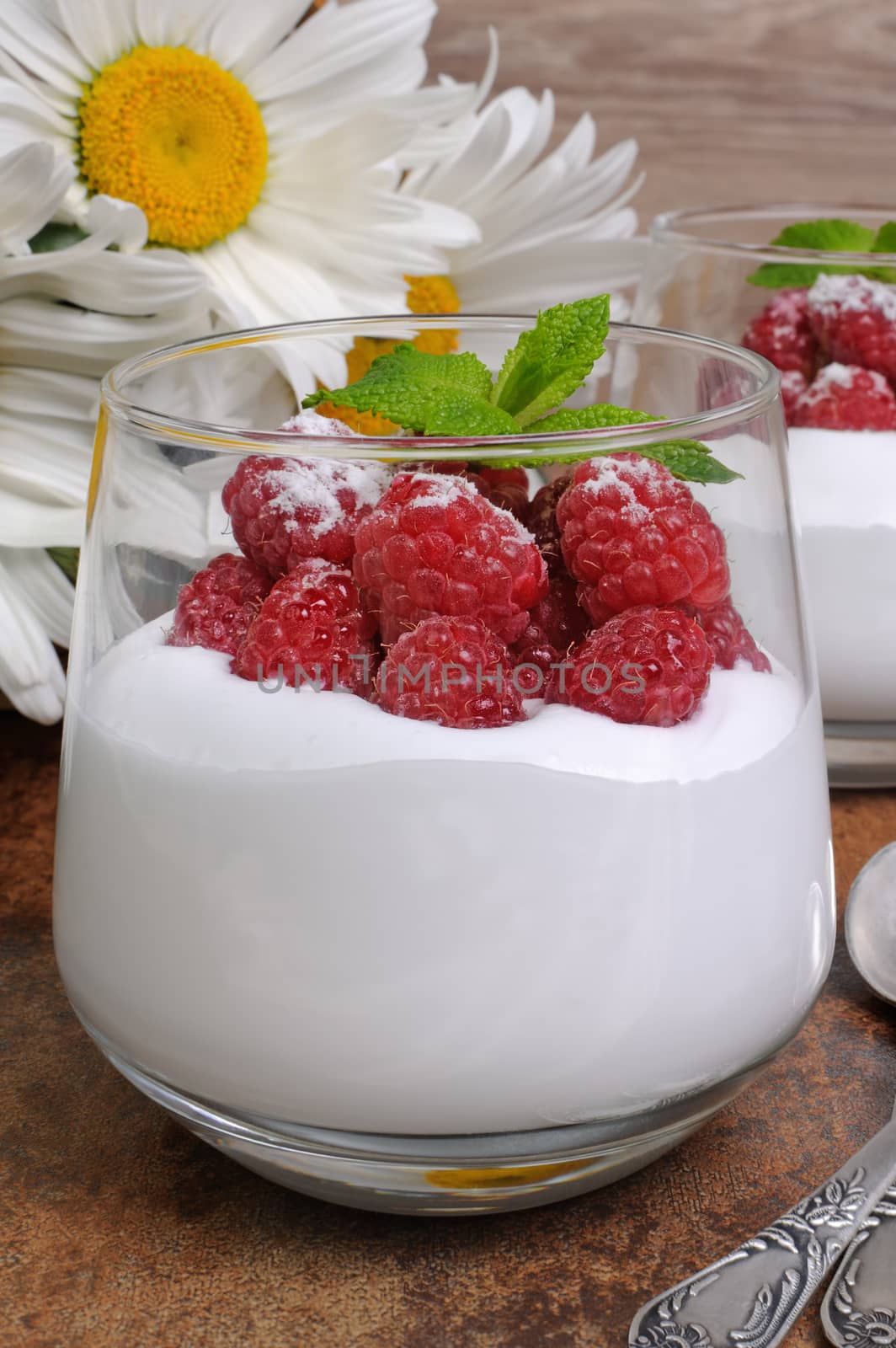 Dessert of whipped cream with raspberries and mint in a glass