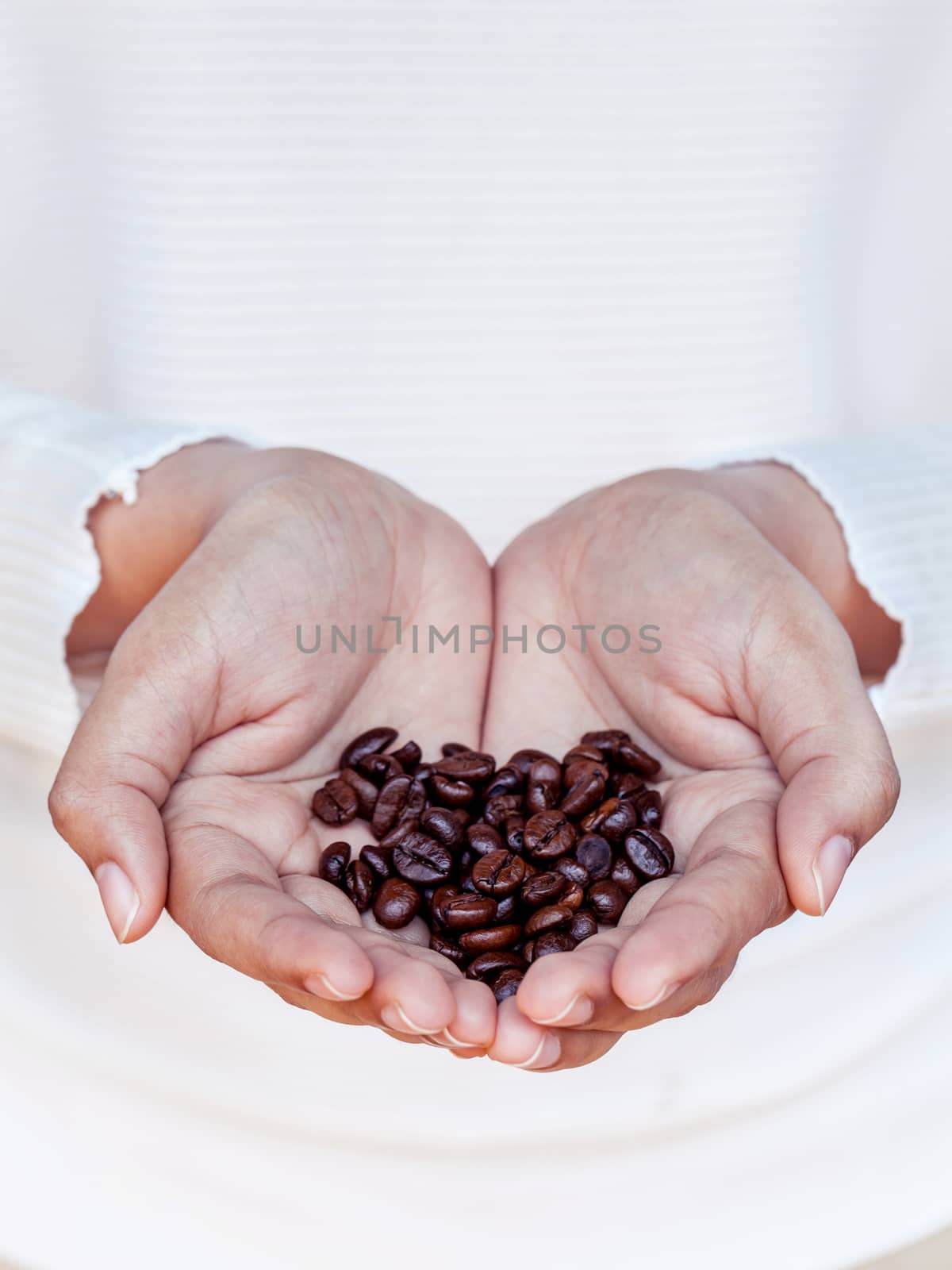 Hand of women holding coffee beans . - Concept for giving refres by kerdkanno