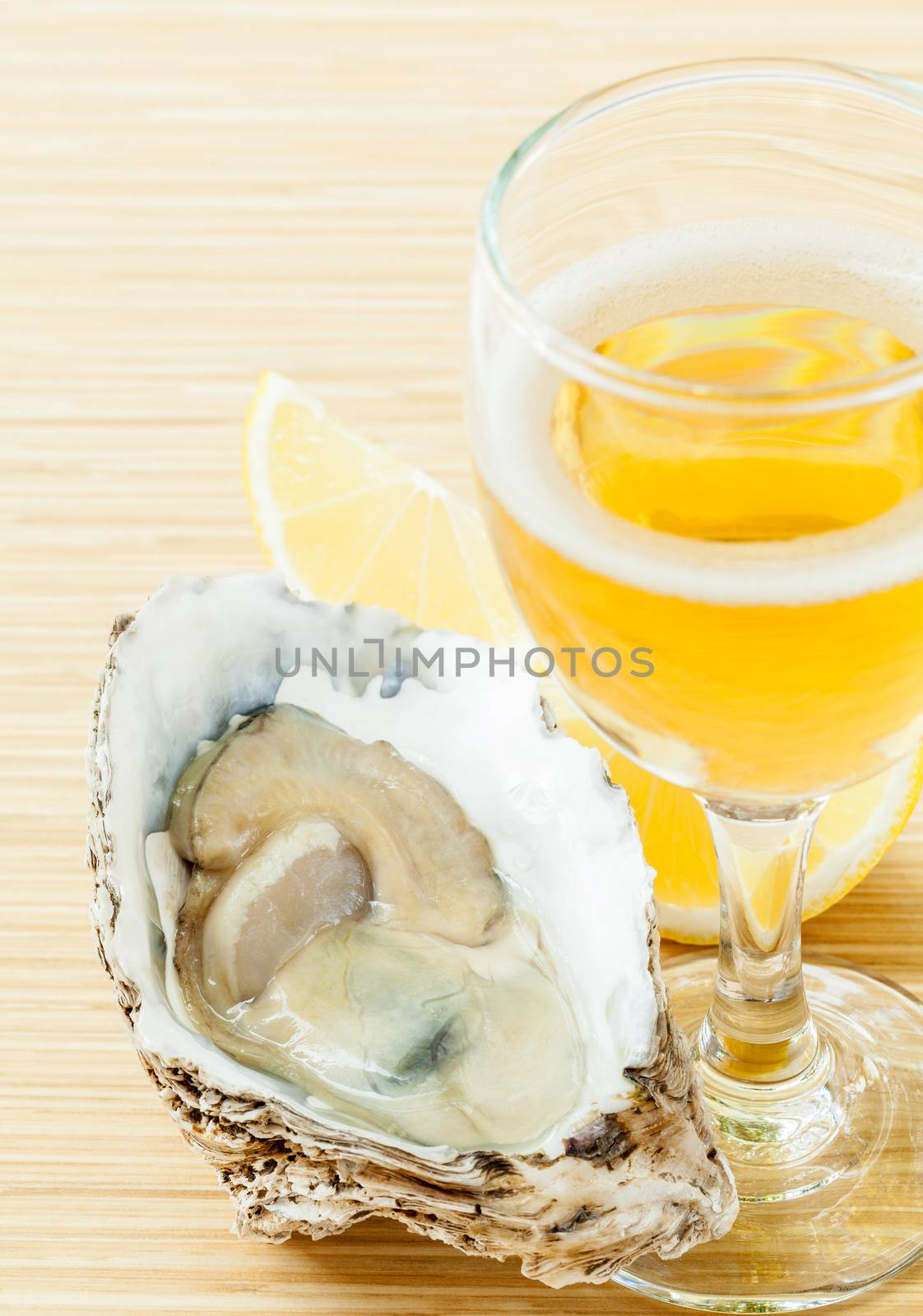 Fresh oysters with lemon and a glass of wine on a wooden table .