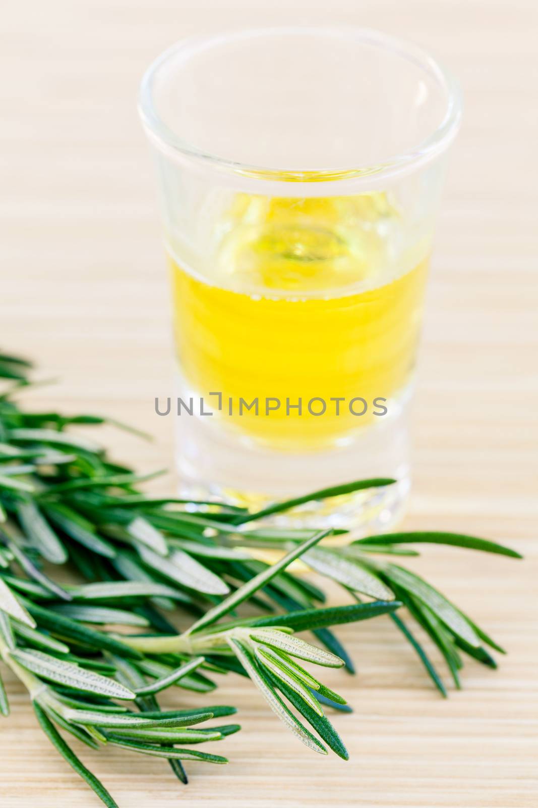 Essential Oil with rosemary on white wooden background. - Macro shot with selective focus.