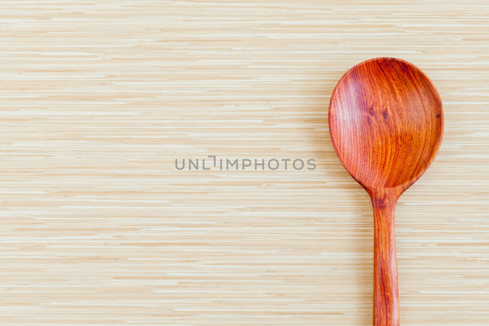 Wooden spoon on wooden background - concept for food and kitchen with copy space.