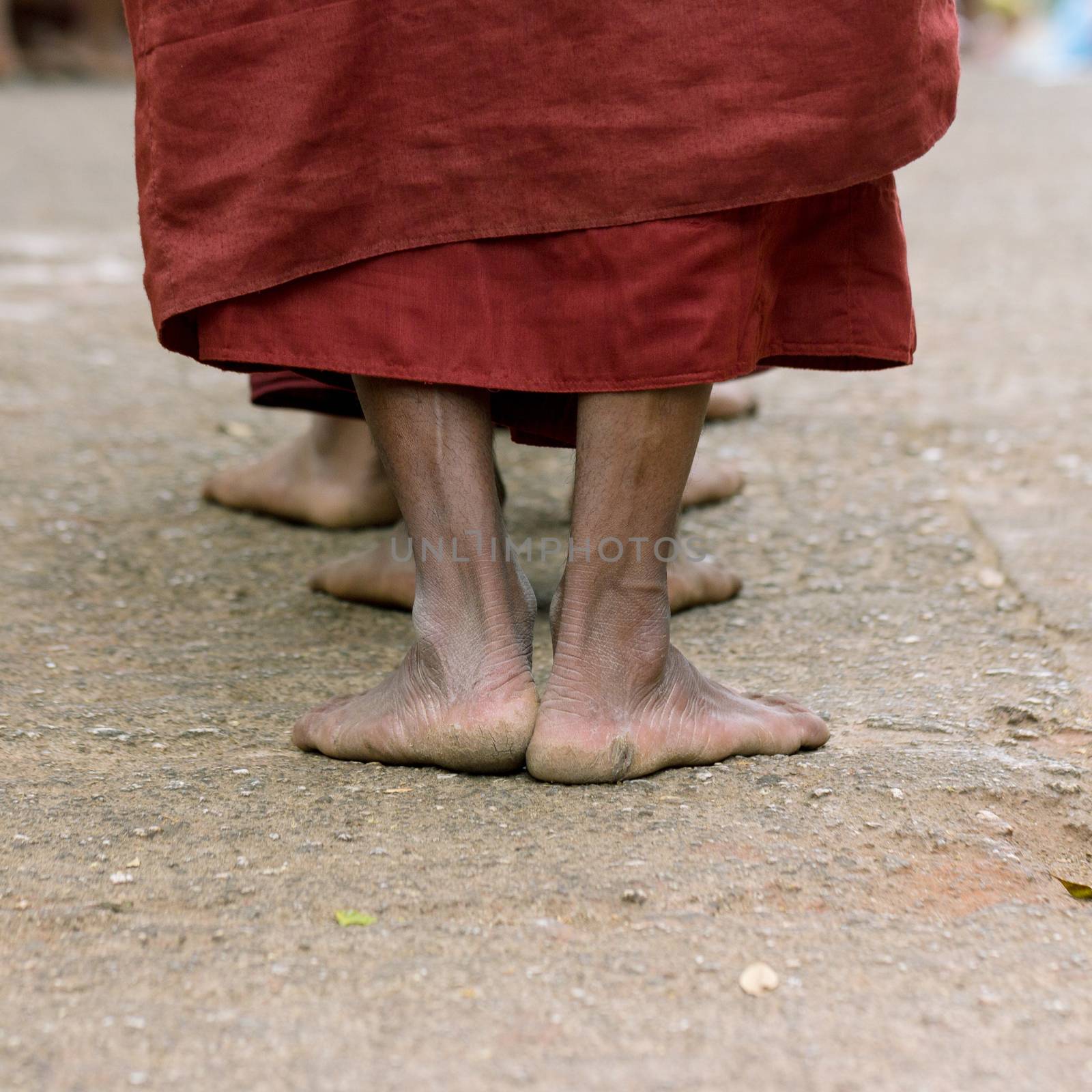 Foots of ascetic Buddhist monk walking at the way to  Kyaikhtiyo.