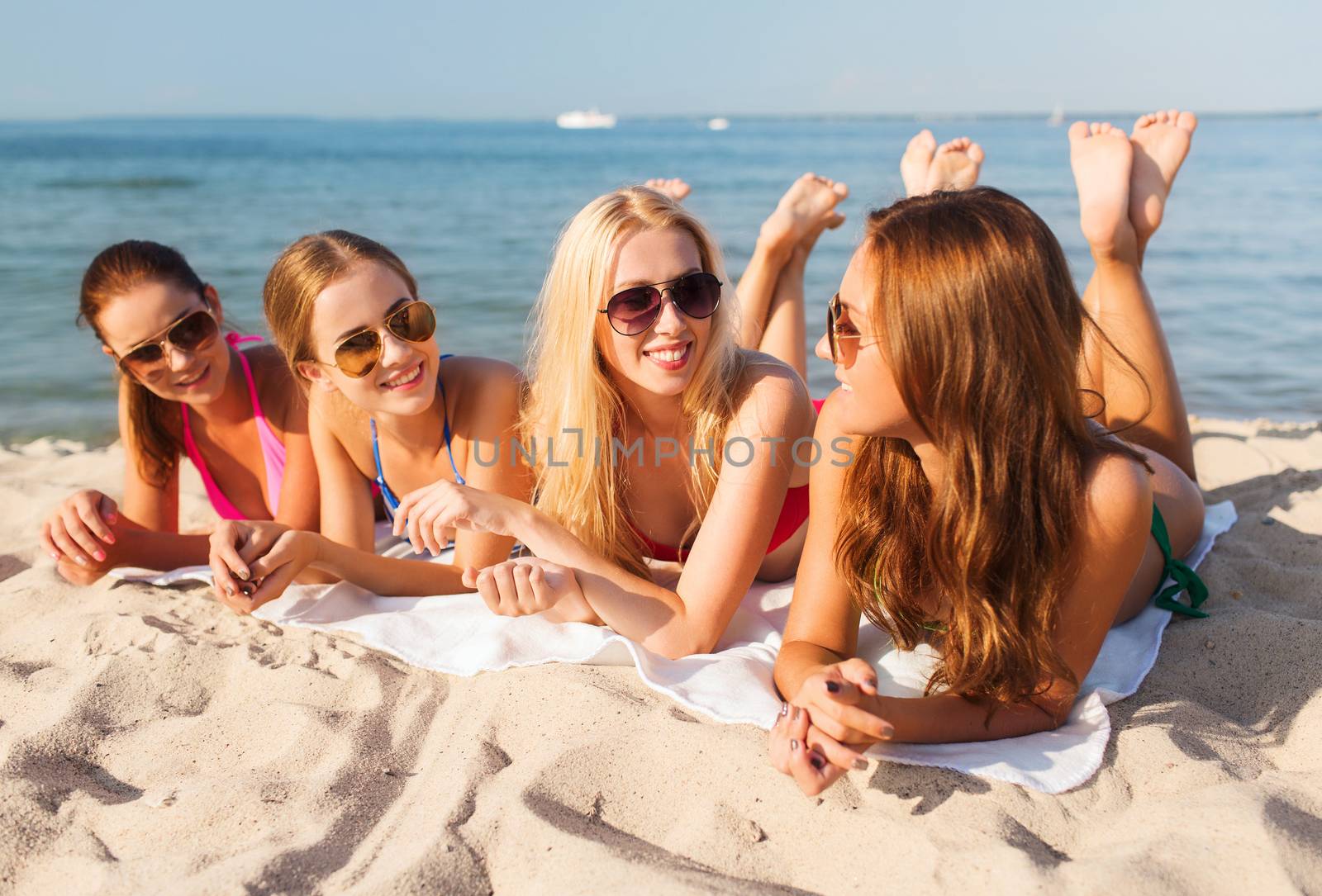 group of smiling women in sunglasses on beach by dolgachov