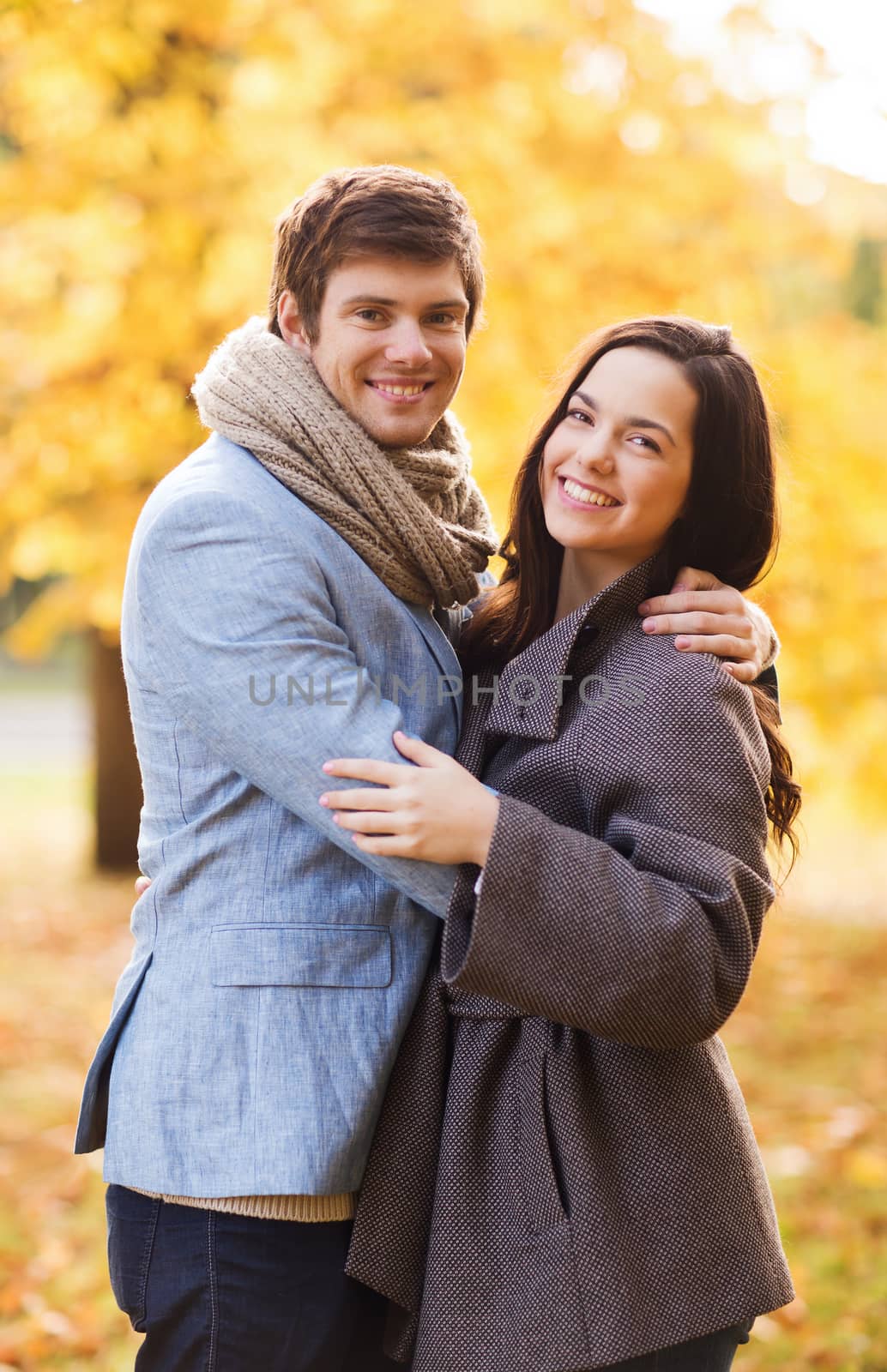 love, relationship, family and people concept - smiling couple hugging in autumn park