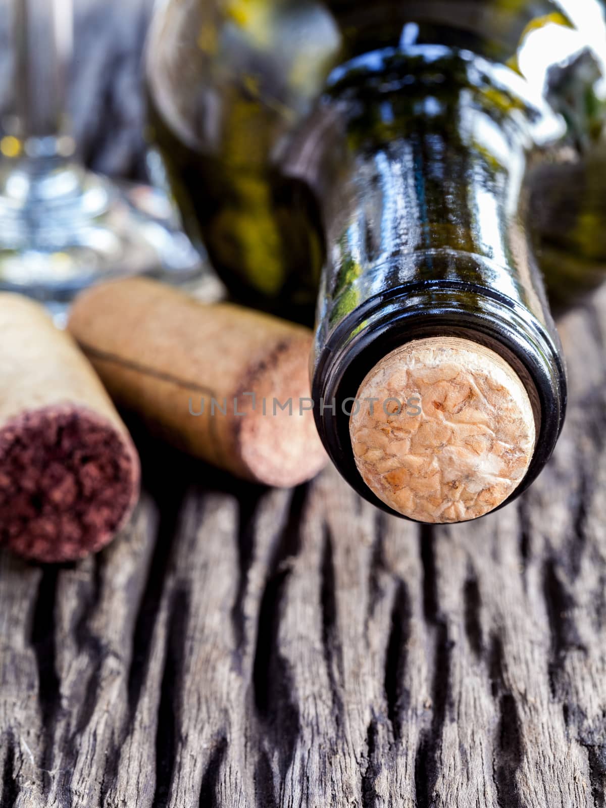 Bottle of wine and corks on wooden table. - Macro shot with sele by kerdkanno