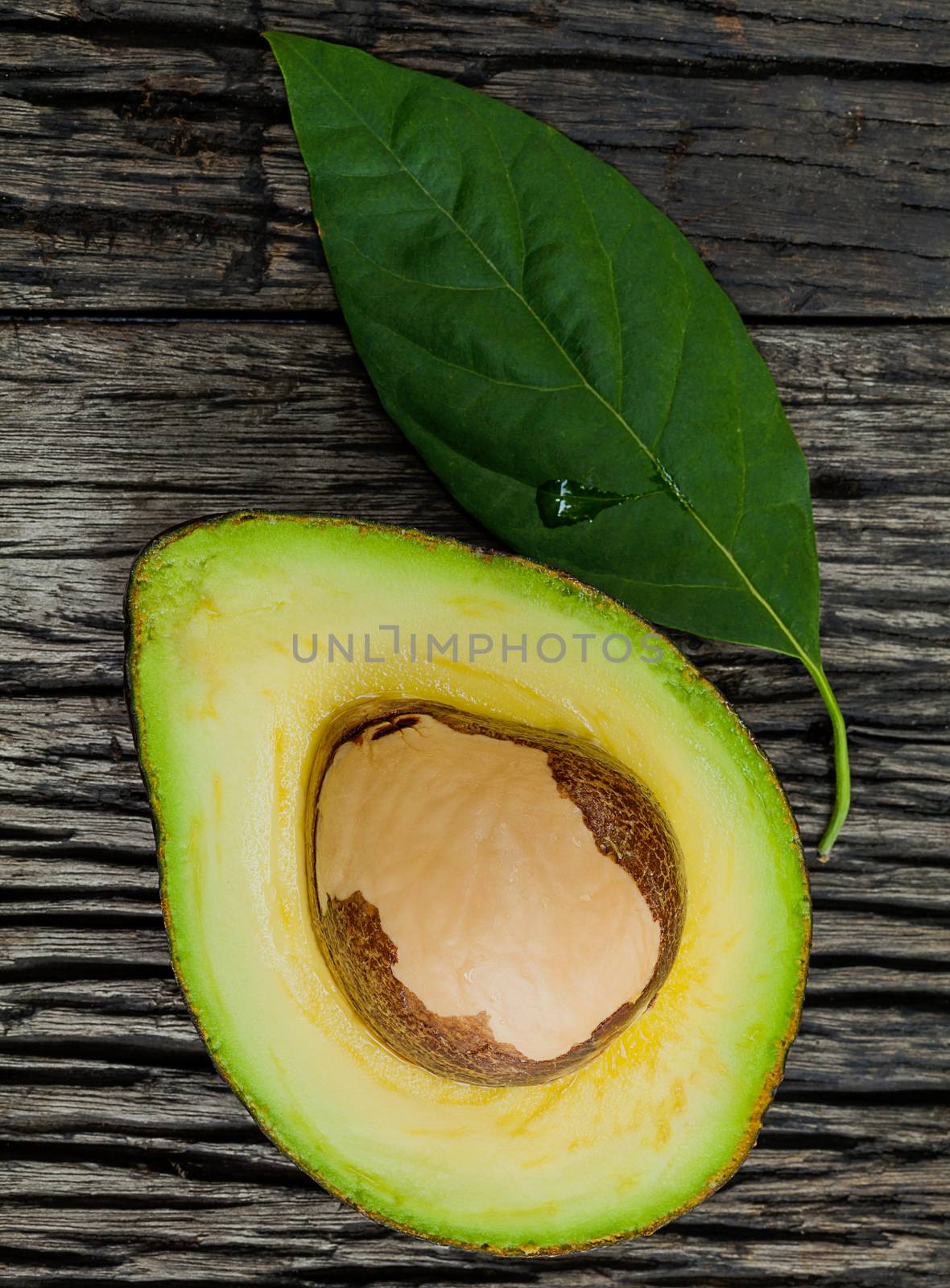 Halved avocado with core in macro shot.