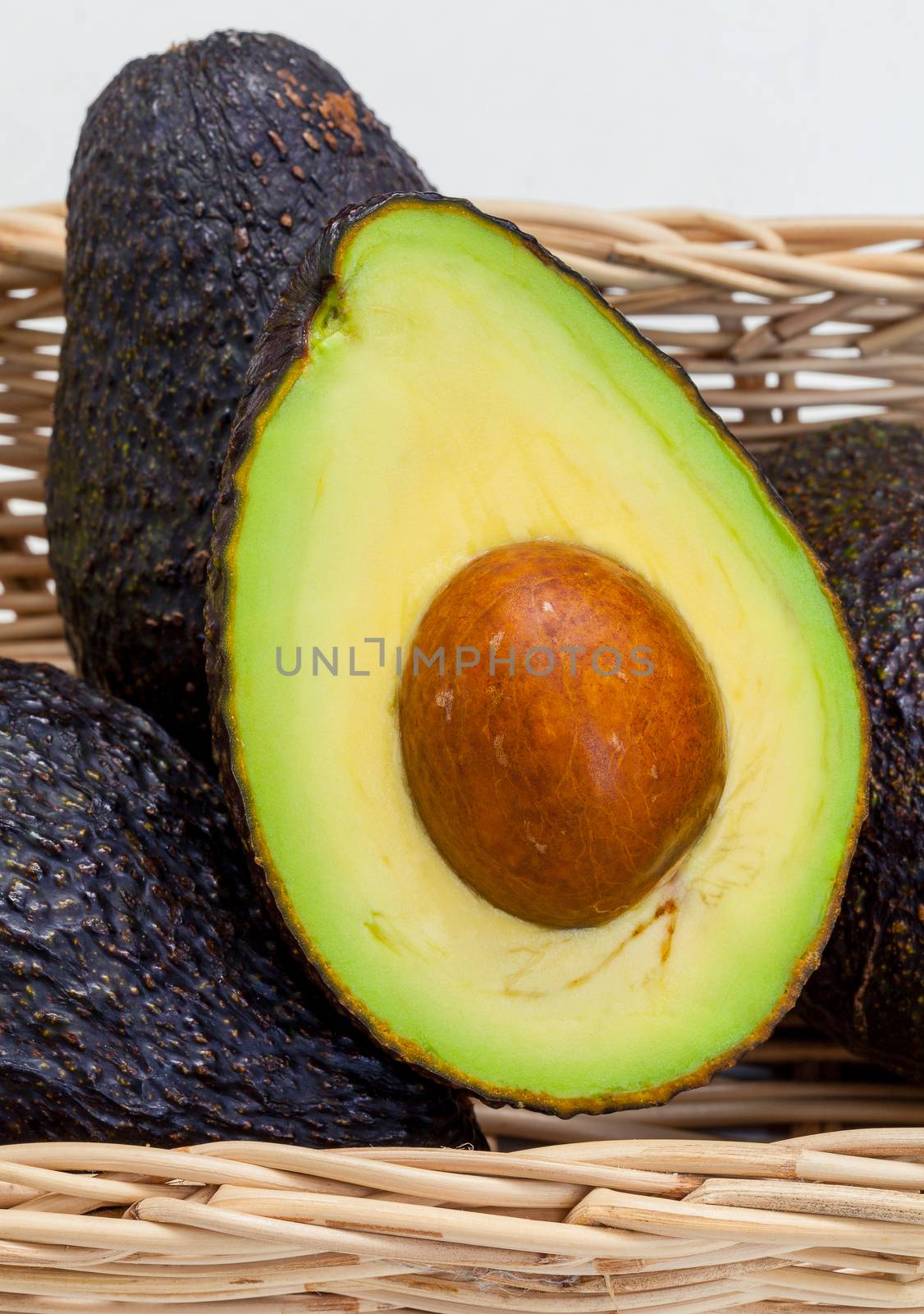 Halved avocado with core - in macro shot. by kerdkanno