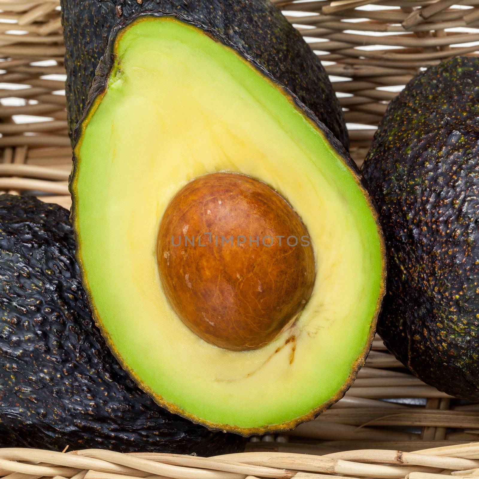 Halved avocado with core - in macro shot.