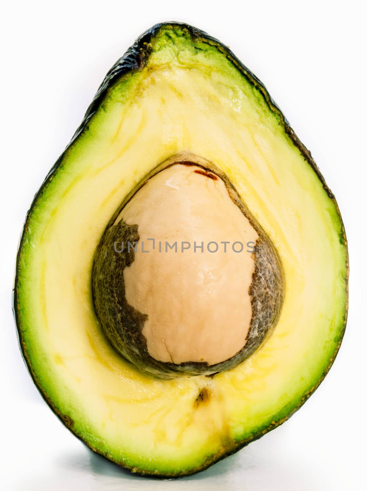 Halved avocado with core isolated on white - in macro shot.