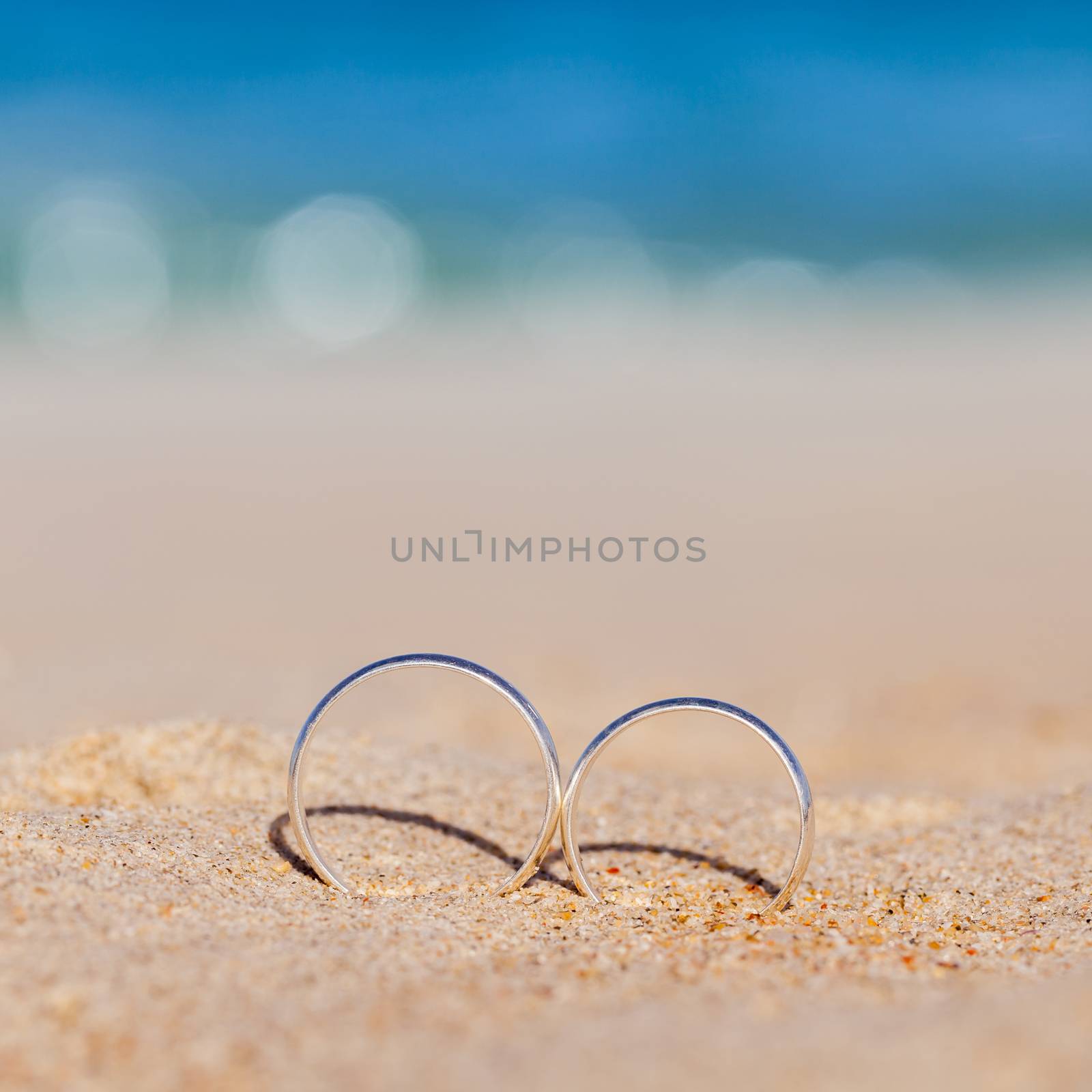 Wedding rings put on the beachside. by kerdkanno