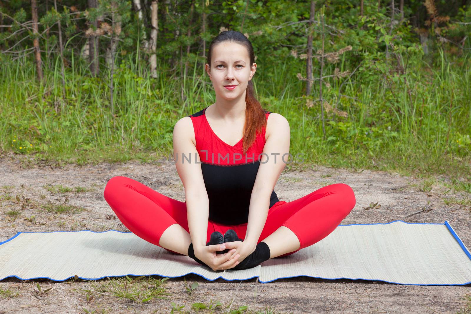 The young girl engaged in yoga class in a forest glade