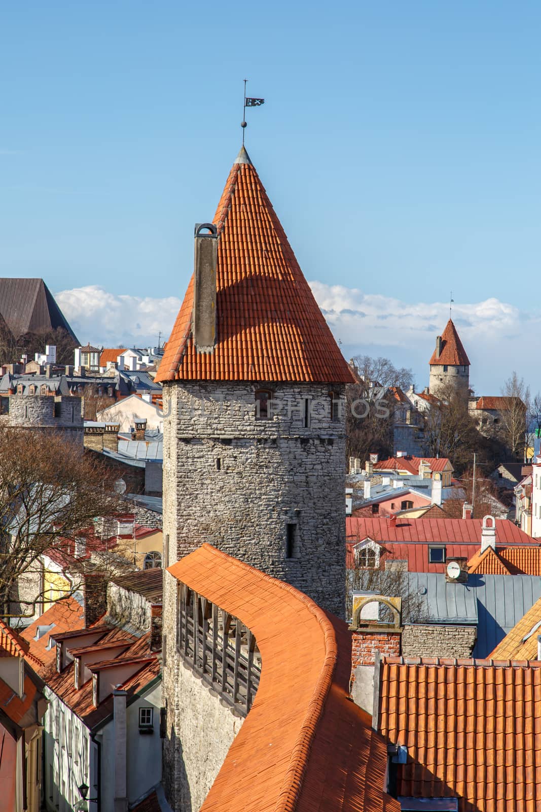 Outside view of ancient fortress walls with towers, exterior view of historical stone Tallinn Walls, on blue cloudy background.