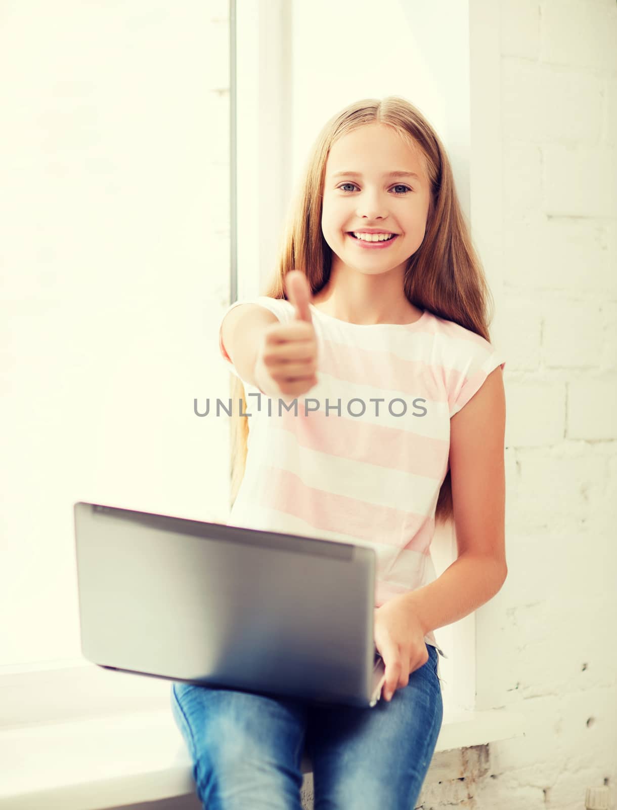 education, school, technology and internet concept - little student girl with laptop pc at school