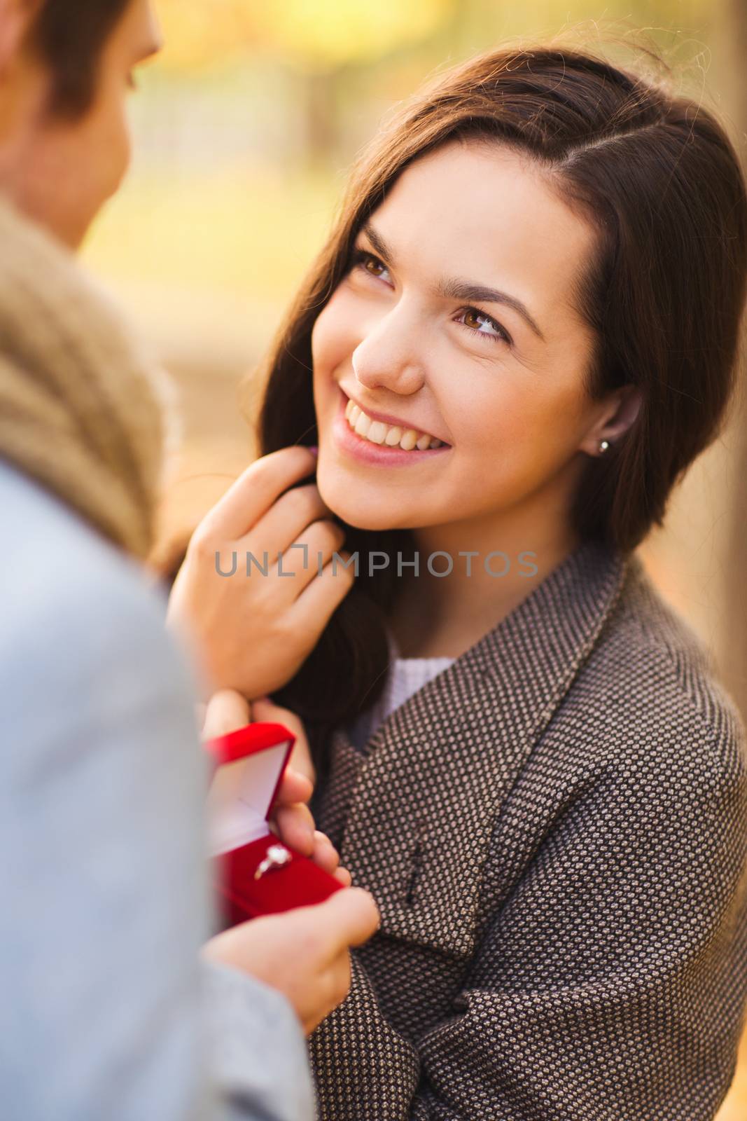 love, relationship, family and people concept - close up of smiling couple with red gift box in autumn park
