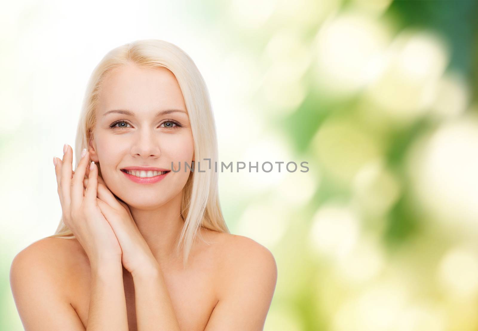health and beauty concept - face and hands of happy woman