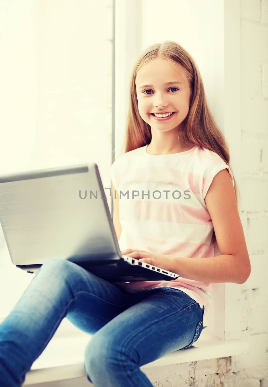 education, school, technology and internet concept - little student girl with laptop pc at school