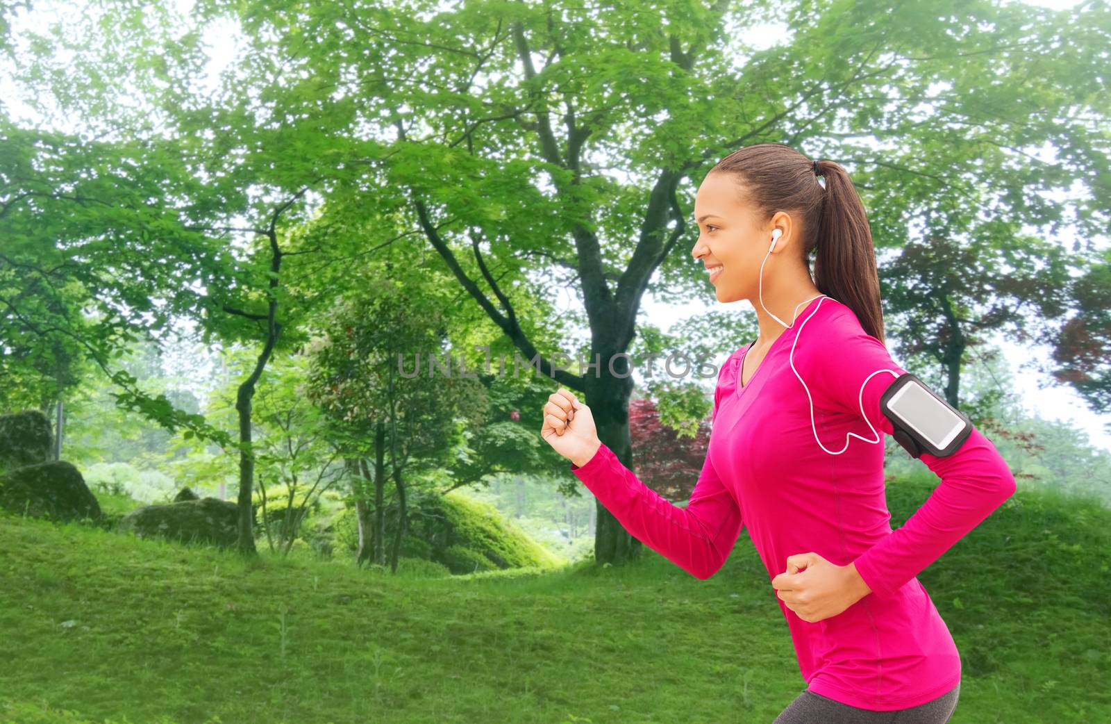 sport, fitness, health, technology and people concept - smiling young african american woman running with smartphone and earphones outdoors