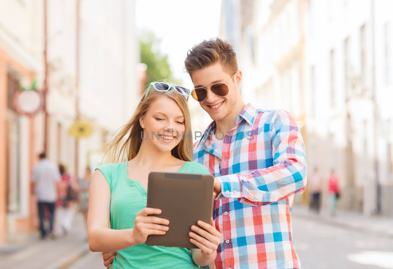 smiling couple with tablet pc in city by dolgachov