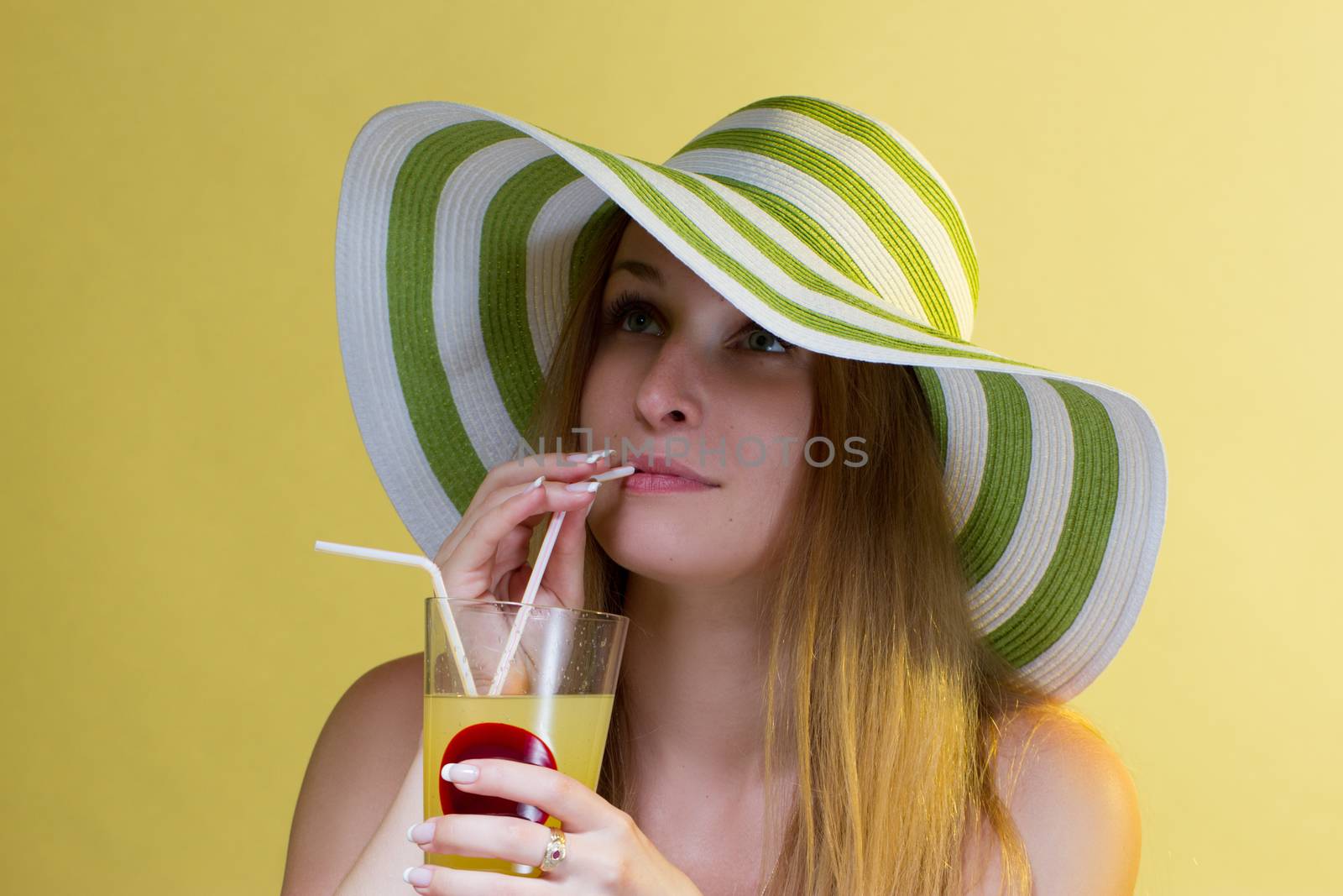 Woman drinking a cocktail over colorful background