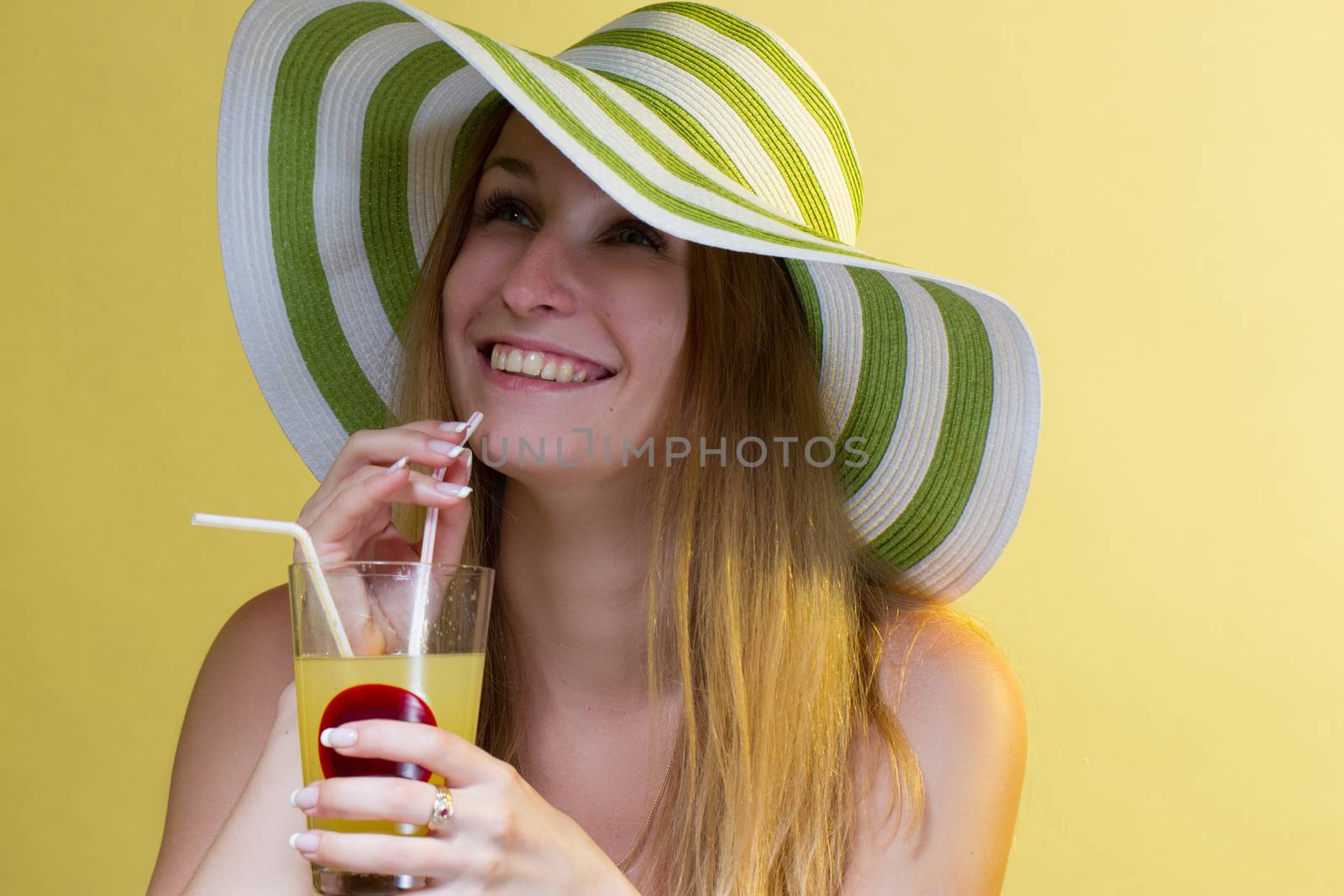 Woman drinking a cocktail over colorful background