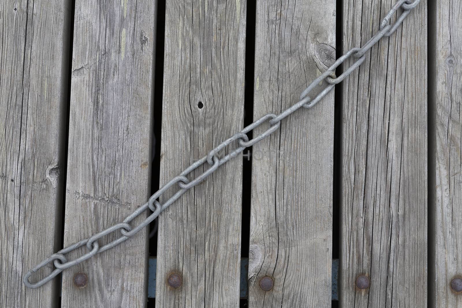 A jetty wtih a chain laying on it in a diagonal line.