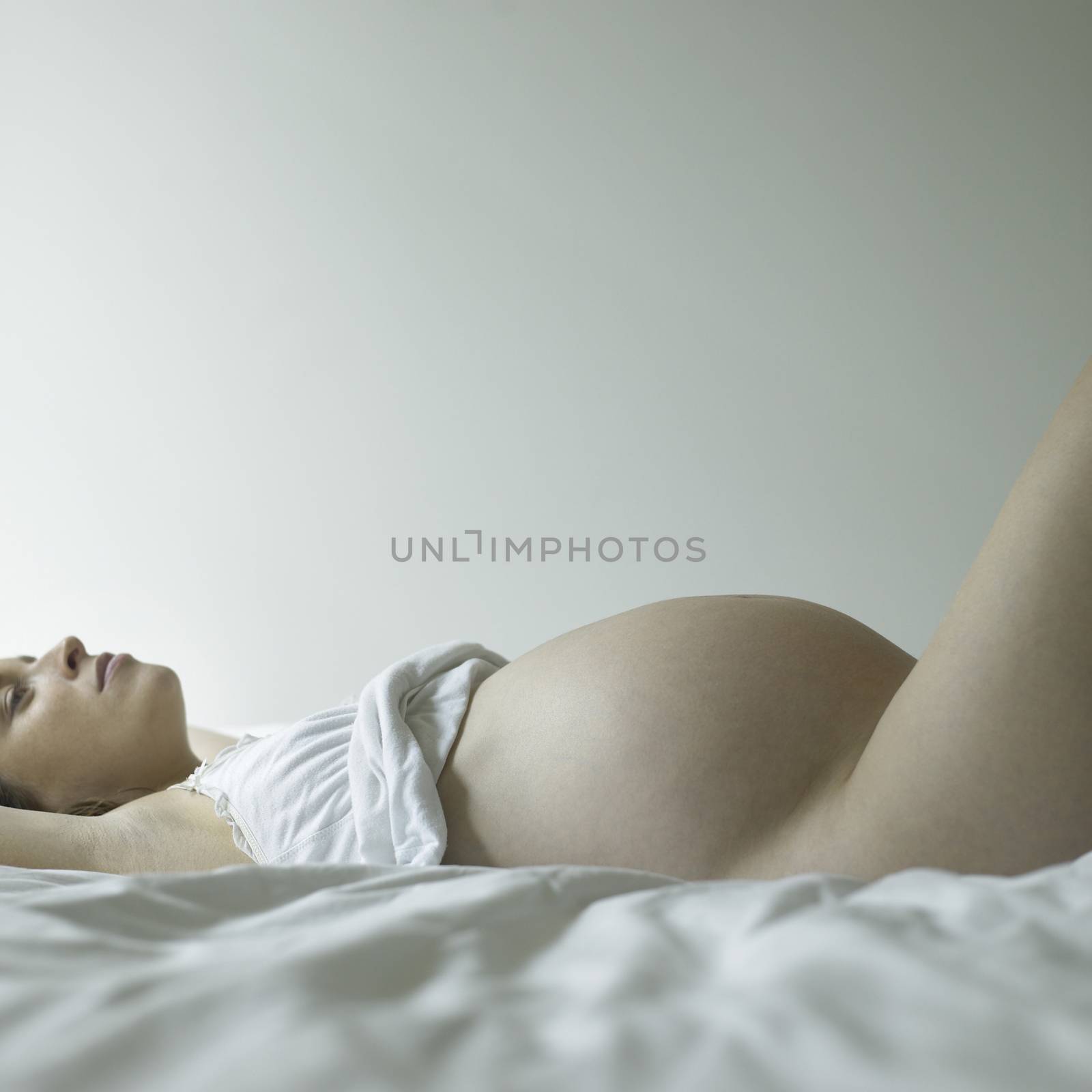 Pregnant woman in shape exposing belly