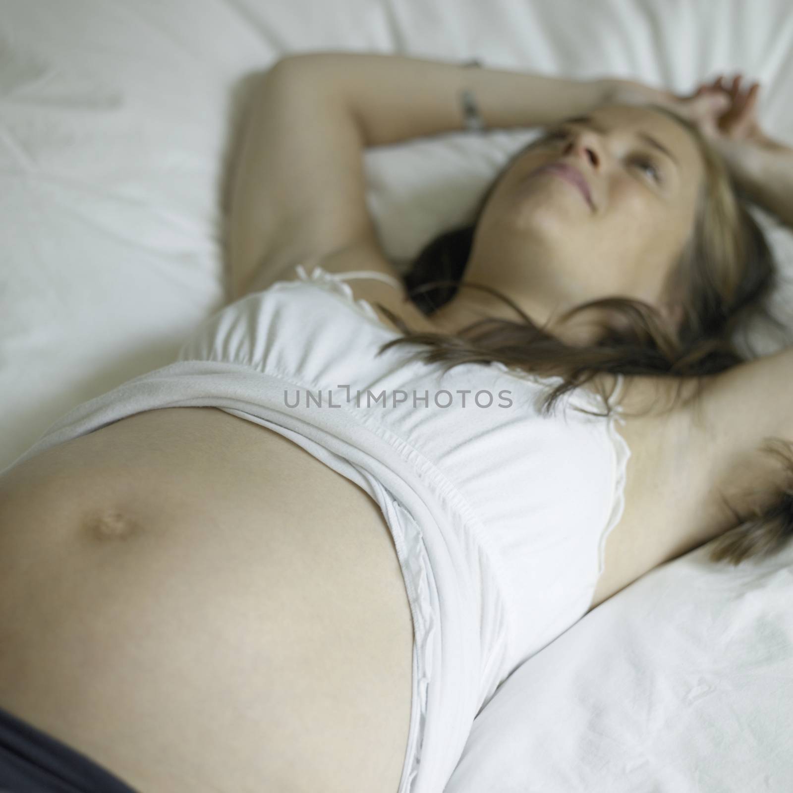 Pregnant woman in shape exposing belly
