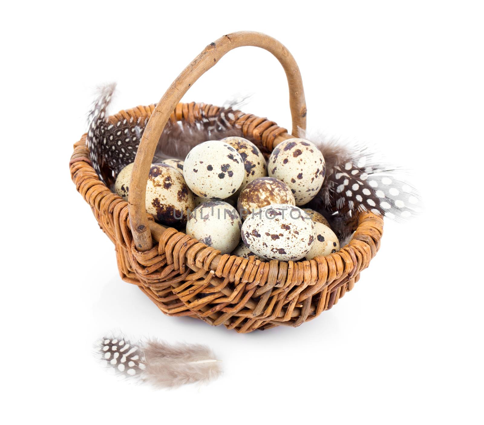 quail eggs in a wicker basket on white background