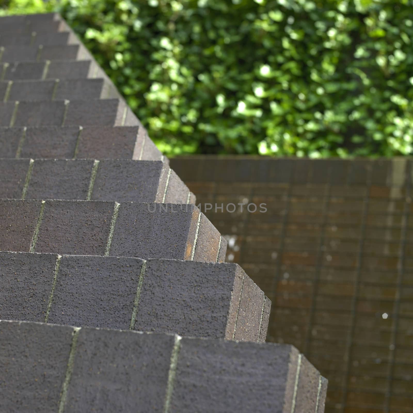 Towering brick pyramid wall in a lush green urban setting