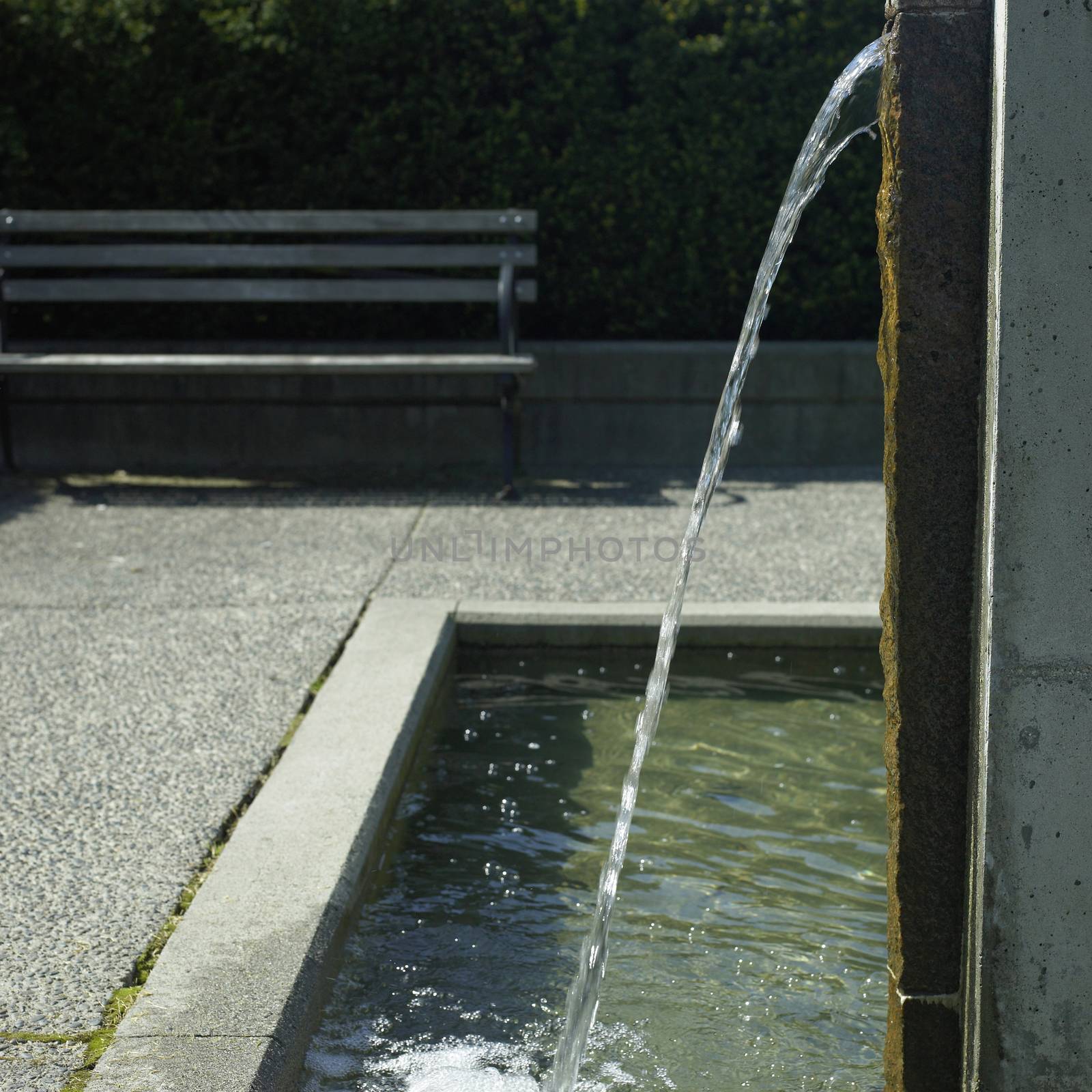 Water spout pours into an urban water feature