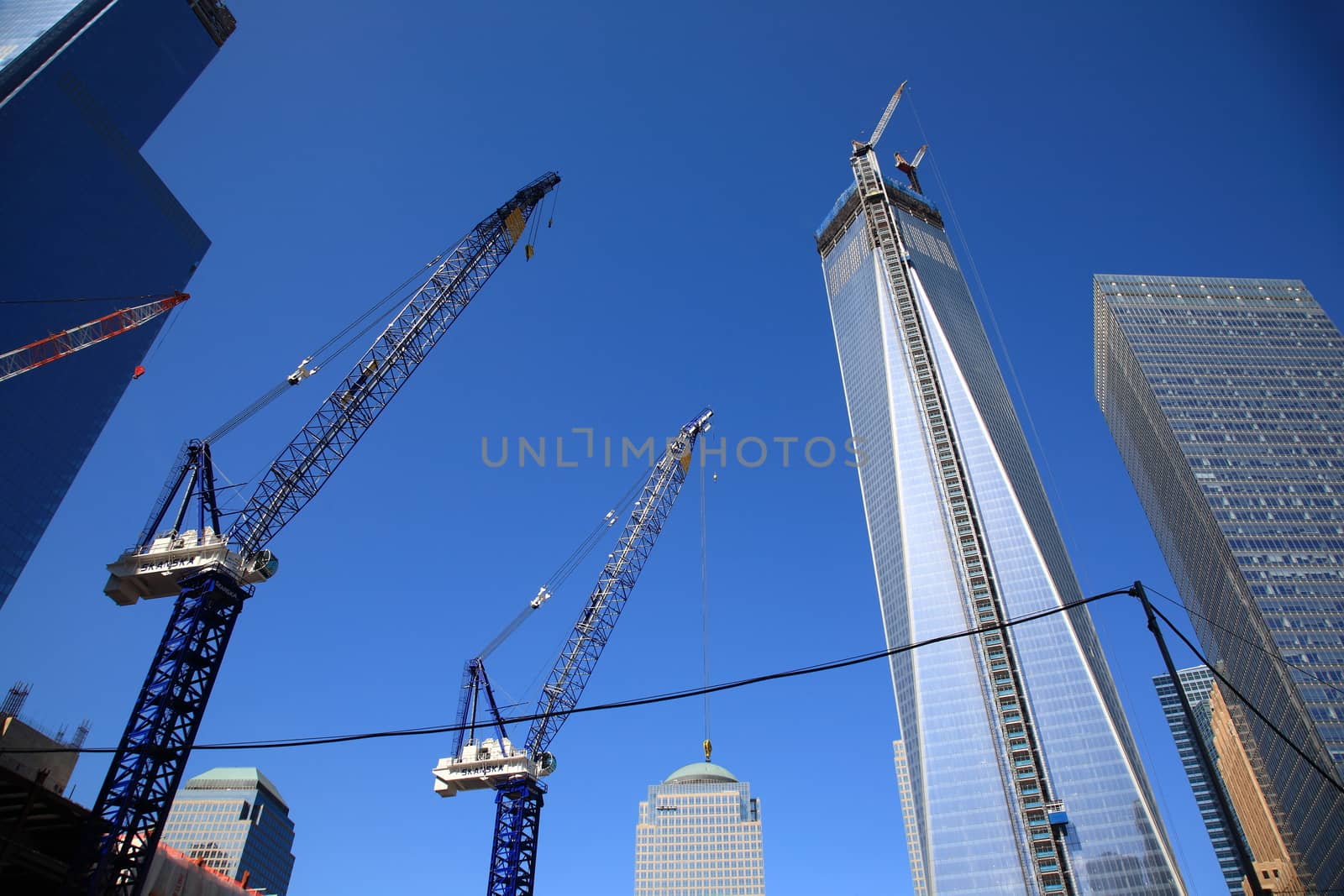 Construction cranes near rising Freedom Tower One World Trade Center in lower Manhattan.