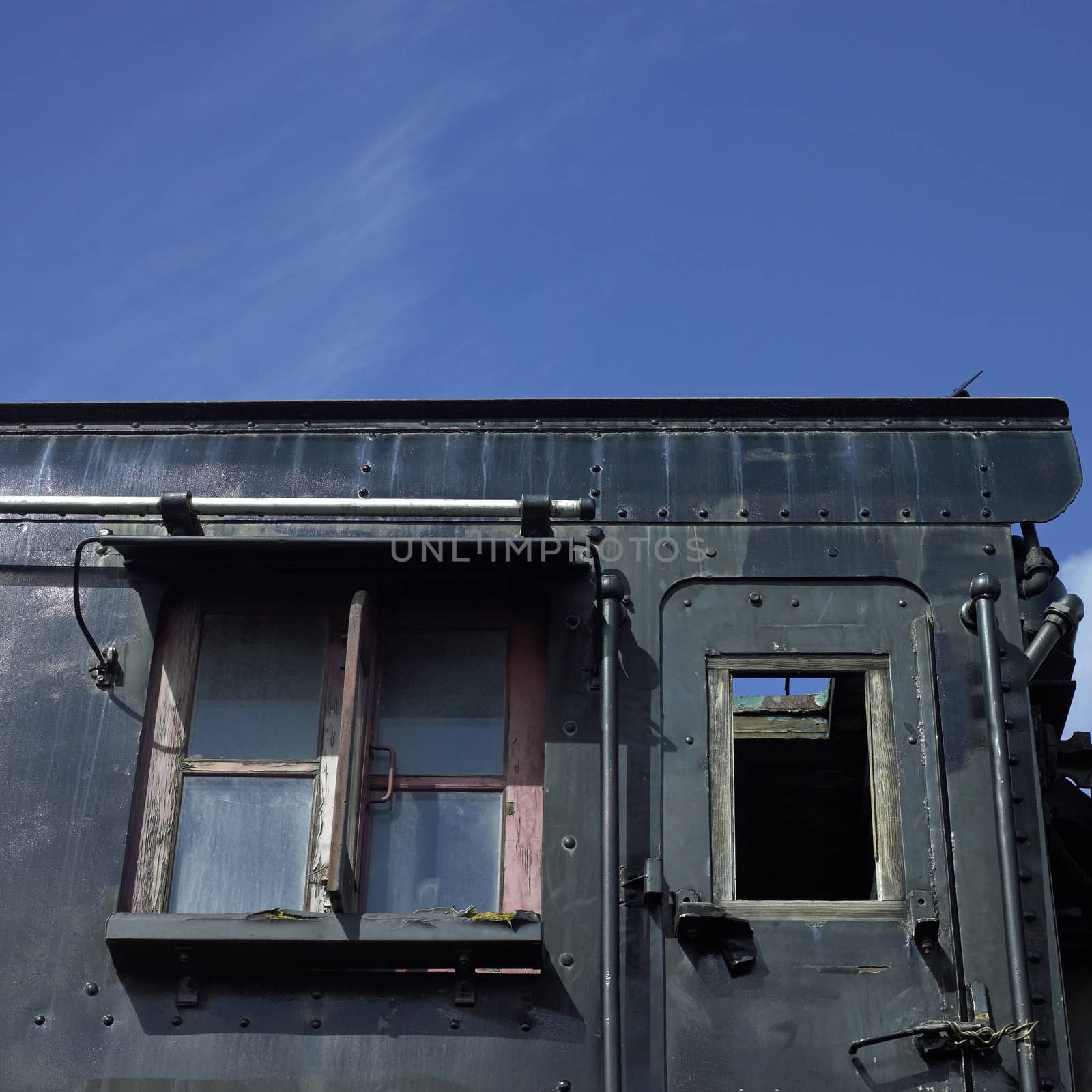 black side of an abandoned rail car featuring door and window