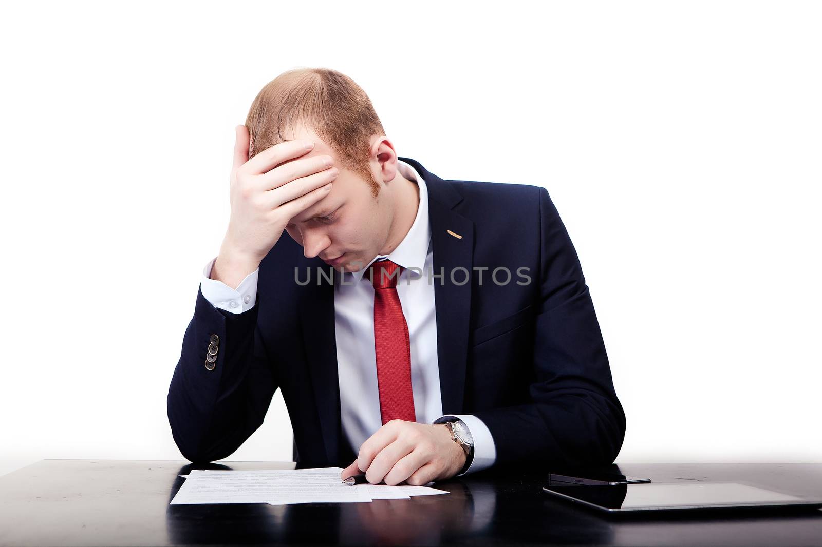 Businessman in red tie at the table took the head after signing the contract. Isolated on white background