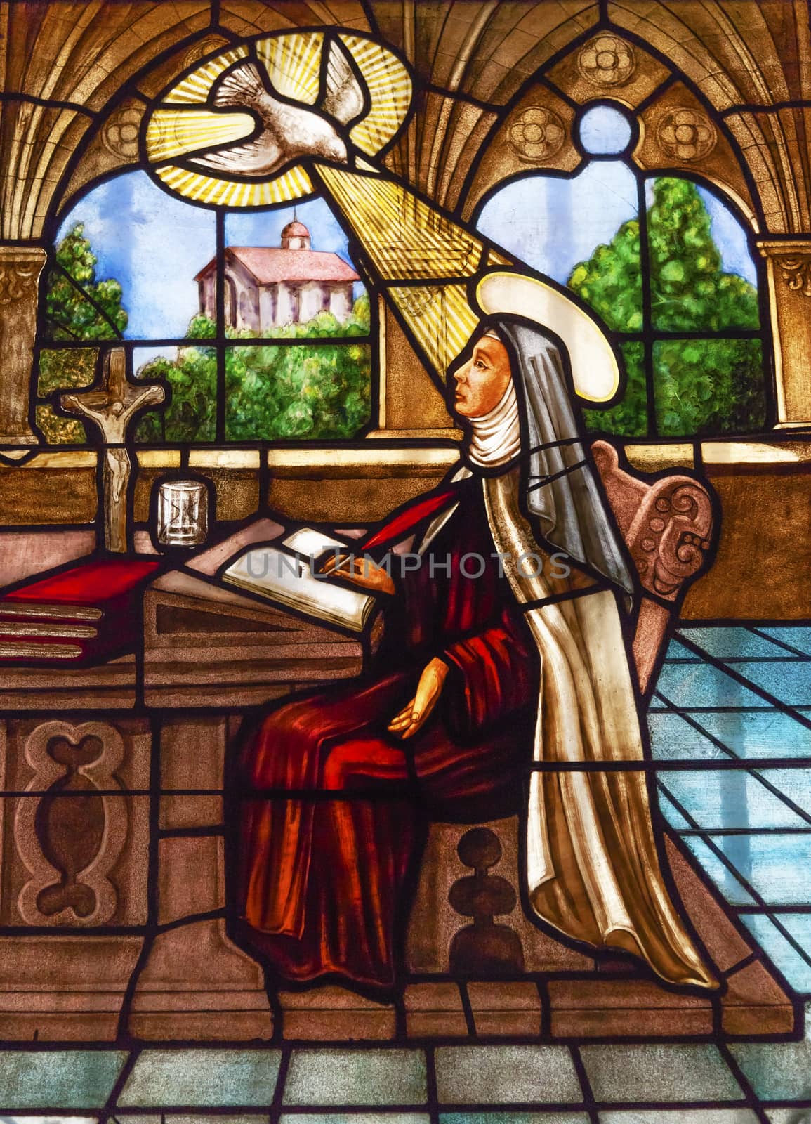 Saint Teresa Writing Stained Glass Convento de Santa Teresa Basilica Avila Castile Spain.  Convent founded in 1636 for Saint Teresa, Catholic nun, Counterreformation author, and Spanish mystic, who founded the Carmelite order. Died in 1582 and made a saint in 1614.
