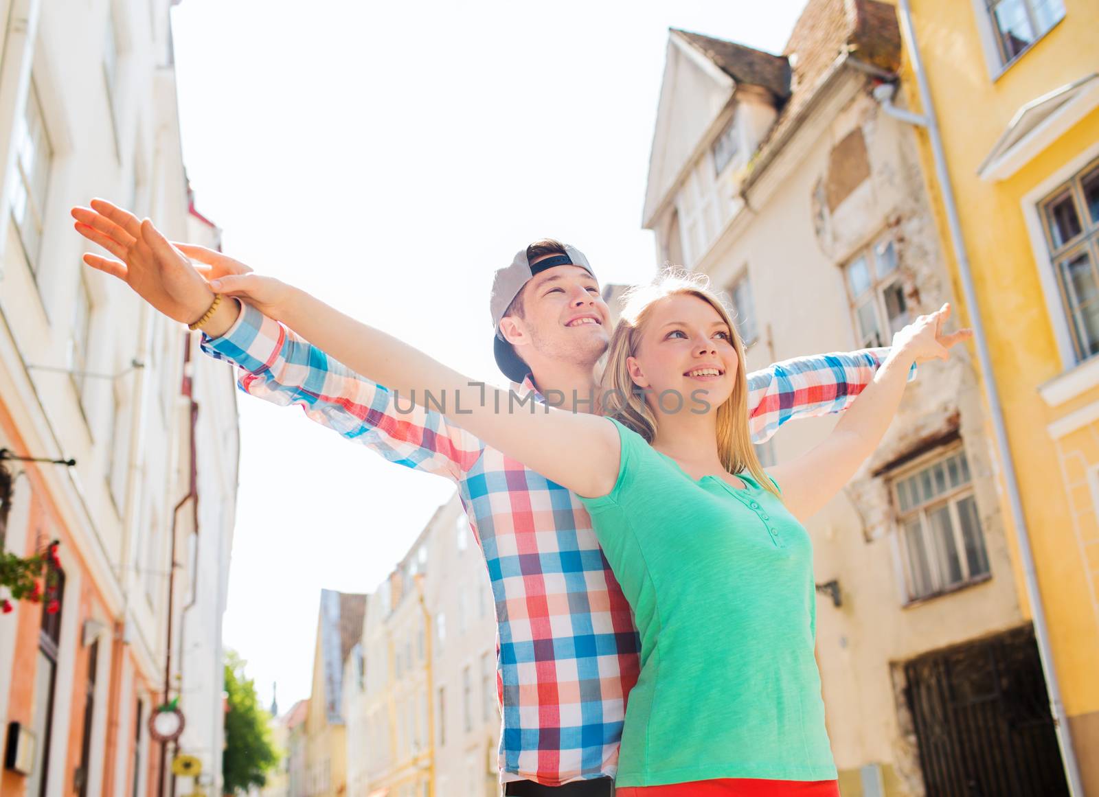 travel, vacation and friendship concept - smiling couple in city