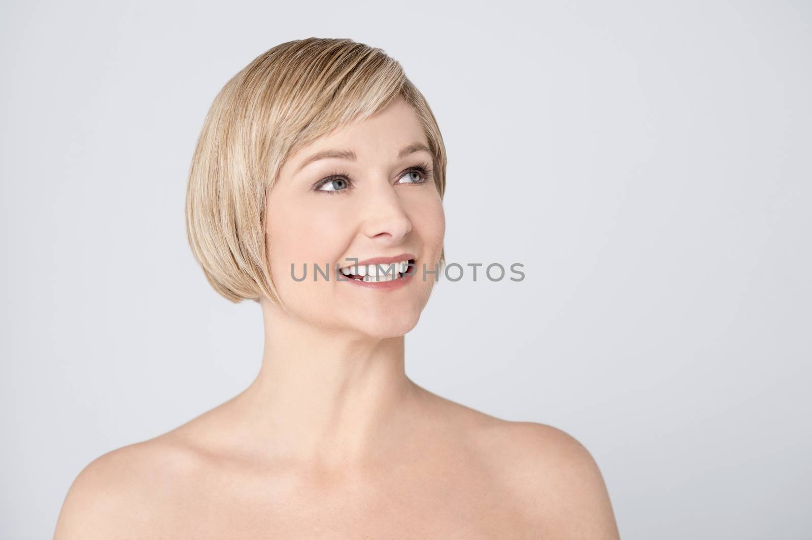 Topless smiling middle aged woman looking up