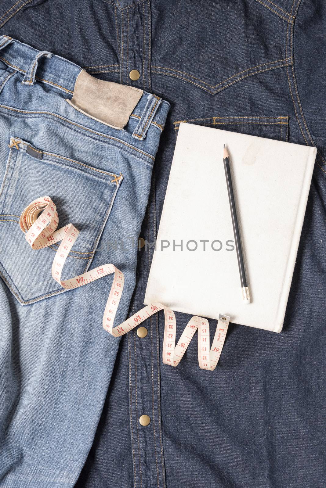 measuring tape and notebook with jean