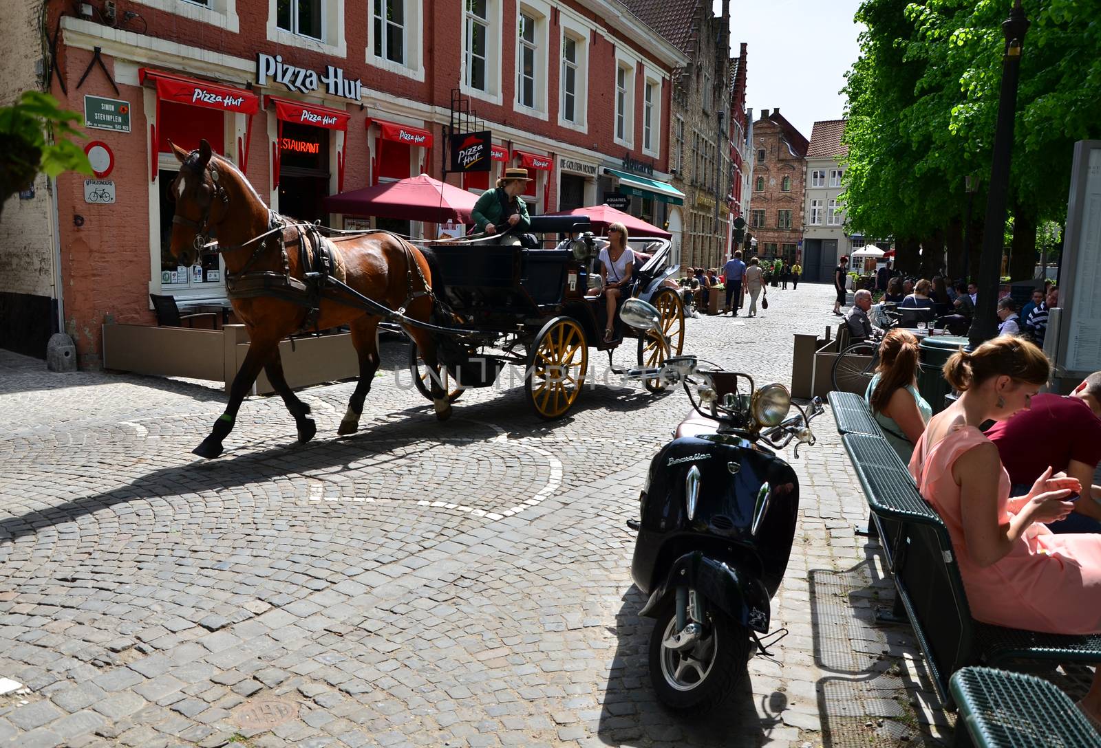 Bruges, Belgium - May 11, 2015: Tourists visit Bruges in traditional horse carriage around the city by siraanamwong